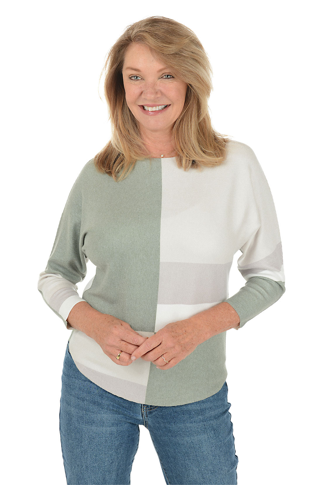 Woman wearing a color-blocked sweater with green and white sections on a white background.