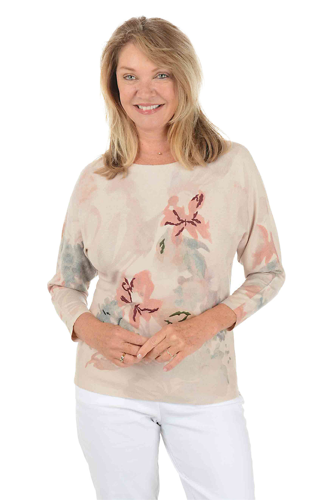 Woman wearing a 3/4 sleeve floral long-sleeve sweater with embroidered accents on a white background.