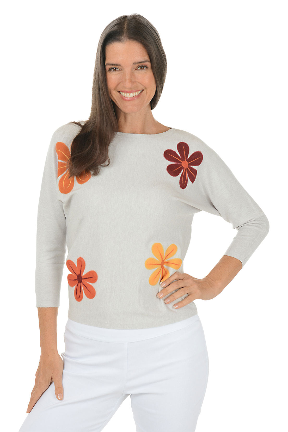 Woman wearing a light gray sweater with floral designs on a white background. Second side shot.