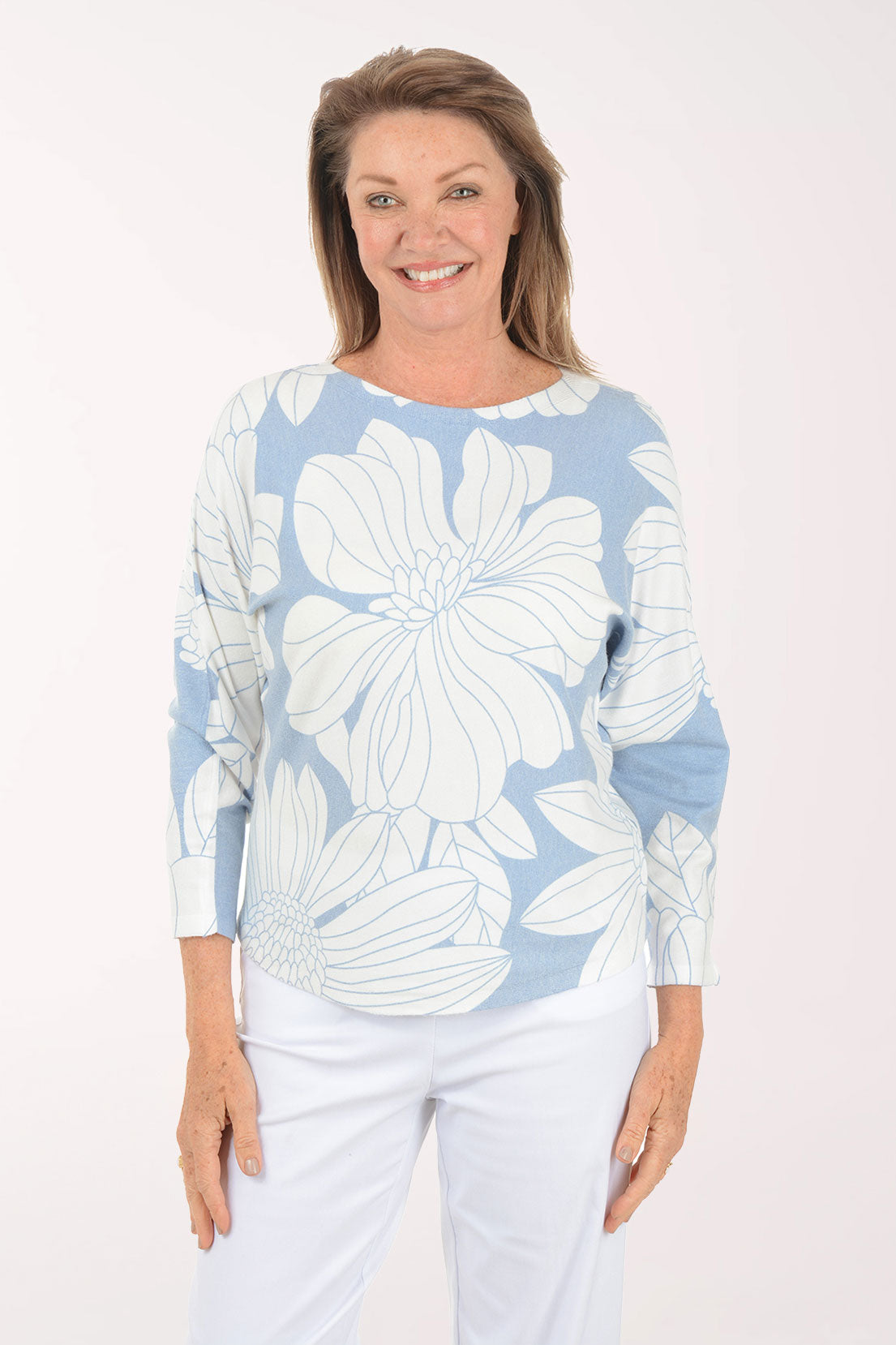 Woman wearing a blue sweater with white flowers.