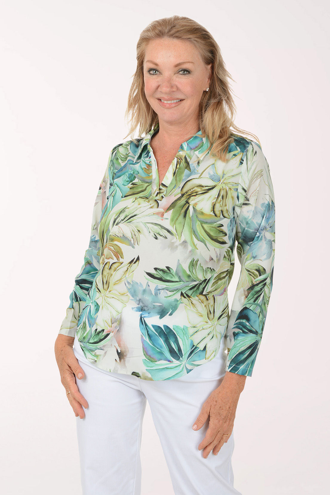 Woman wearing a tropical leaf patterned shirt on a white background