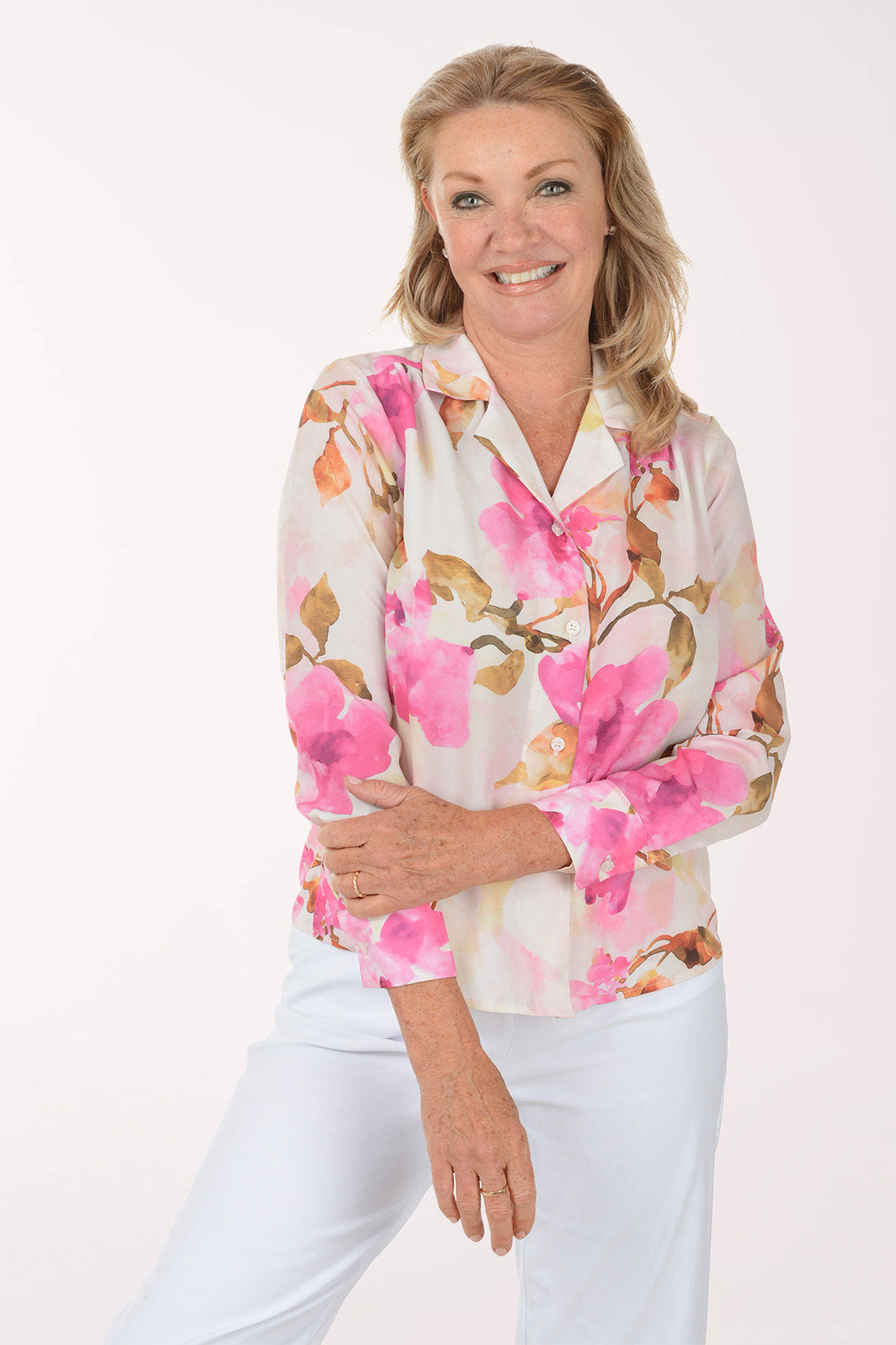 Woman wearing a floral blouse with pink flowers on a white background