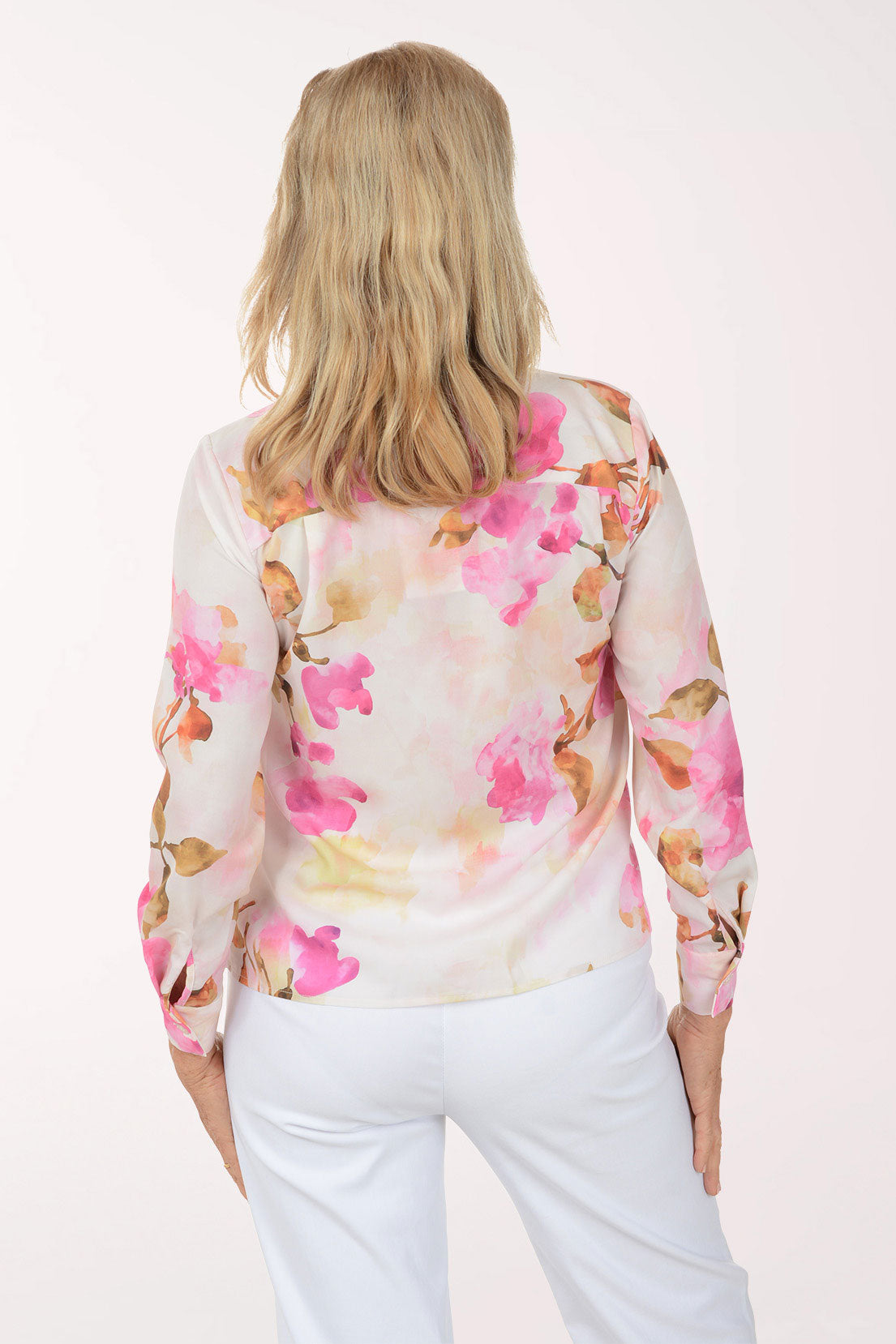 Woman wearing a floral blouse with pink flowers on a white background