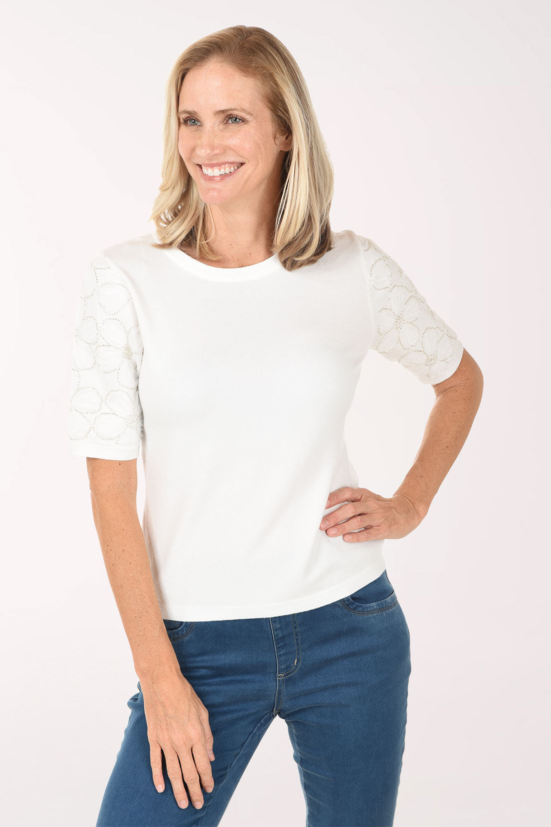 Woman wearing a white t-shirt and blue jeans on a white background