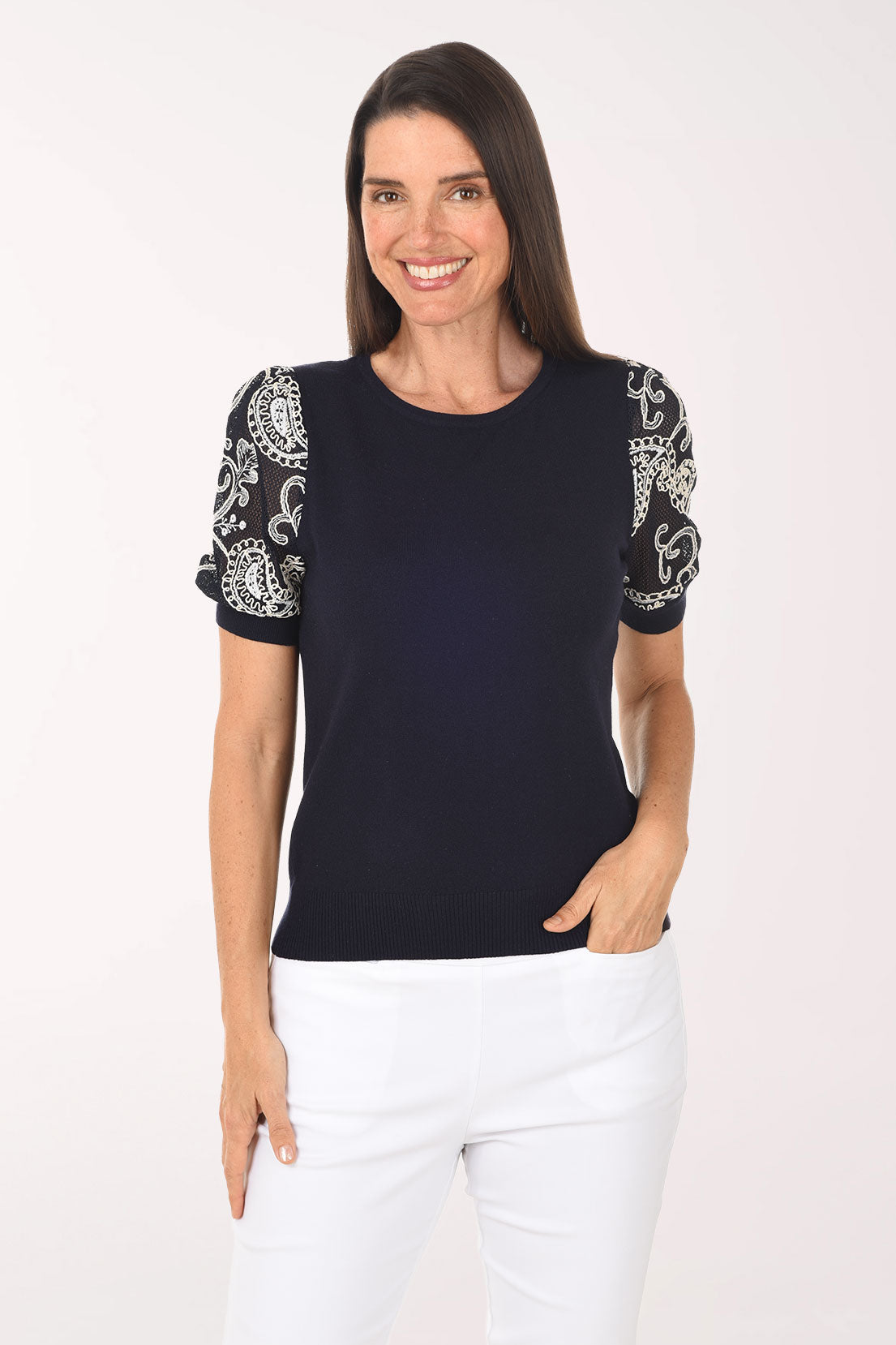 Woman wearing a black top with white patterned sleeves on a white background