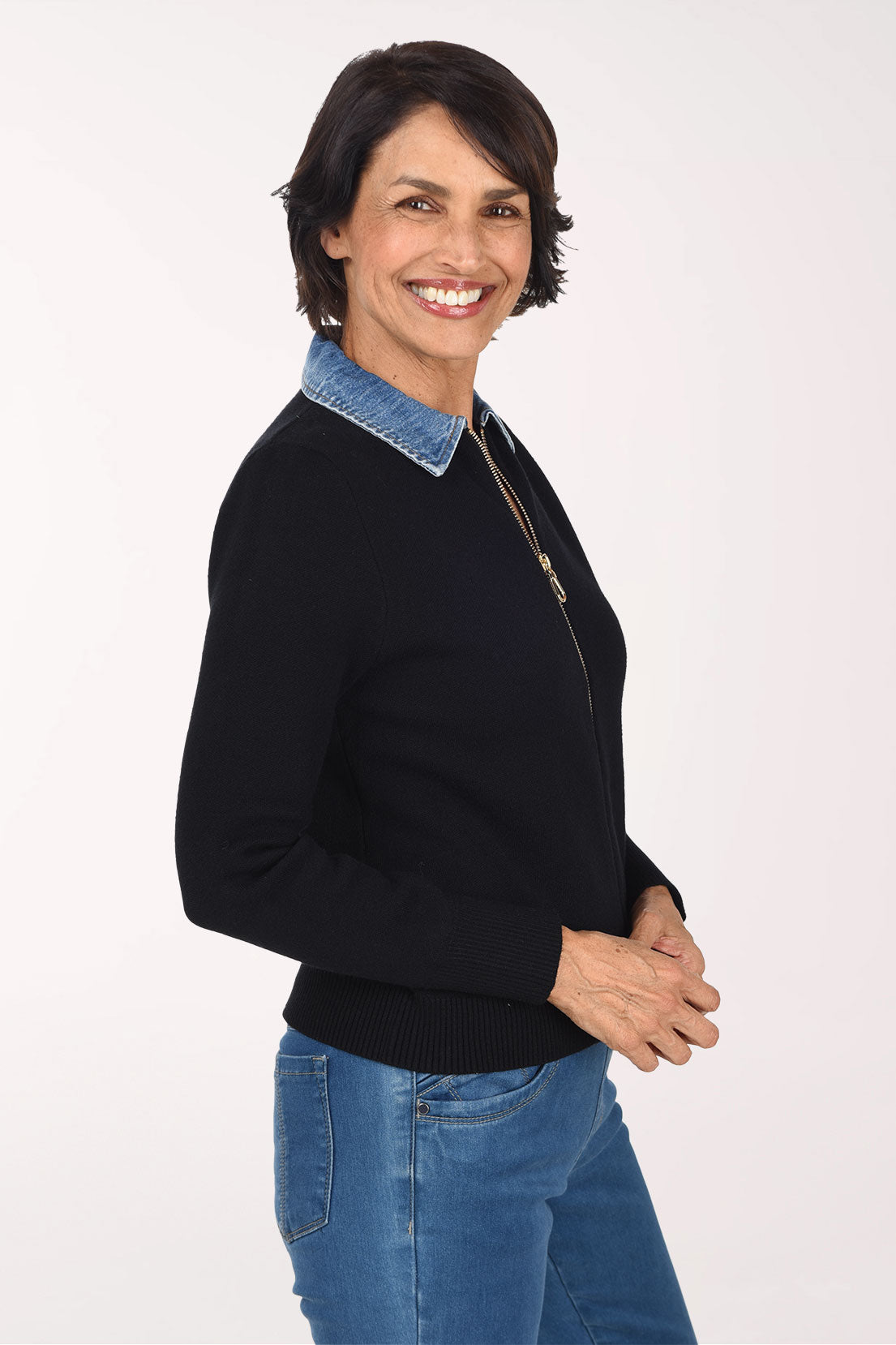 Woman wearing a black zip-up sweater jackets with a denim collar