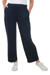 A front shot of a model wearing navy wide leg lounge pants with an elasticized waistband and dual front pockets, paired with white sneakers.