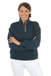 Woman wearing a dark blue pullover with a zipper on a white background.