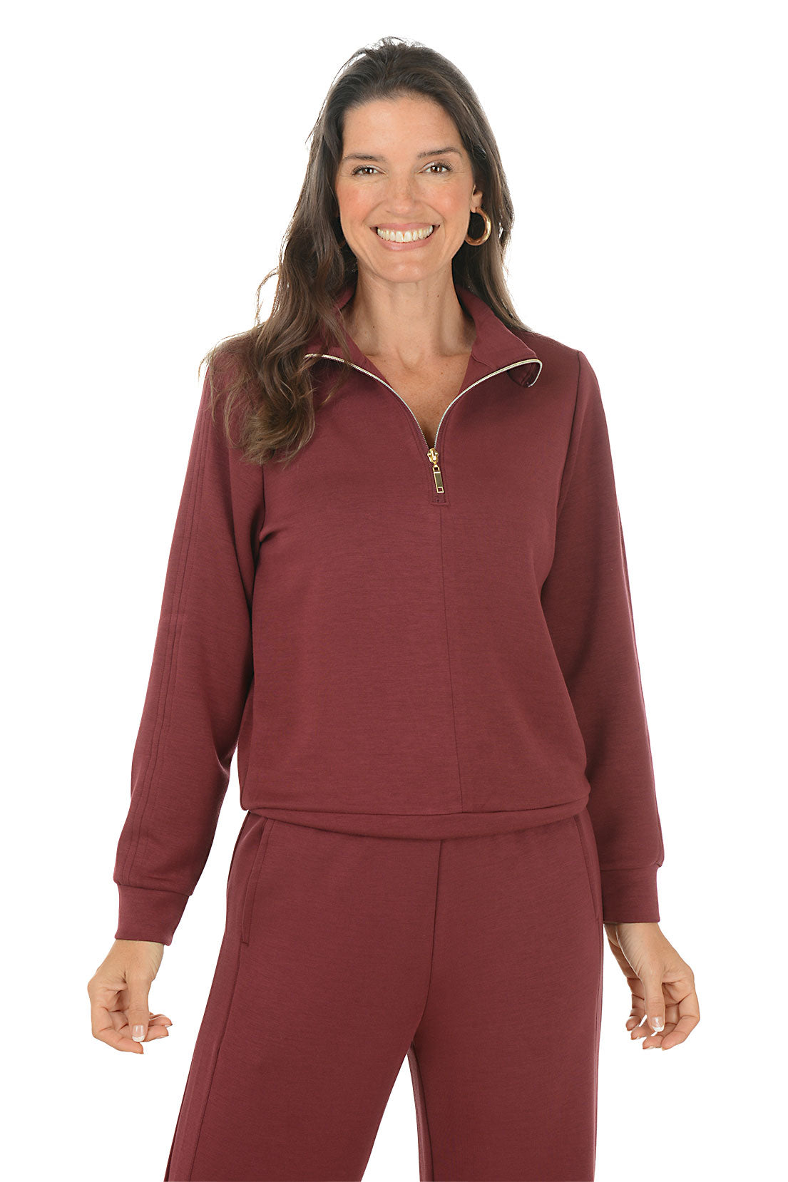 Woman wearing a maroon pullover sweater with a zipper on a white background.