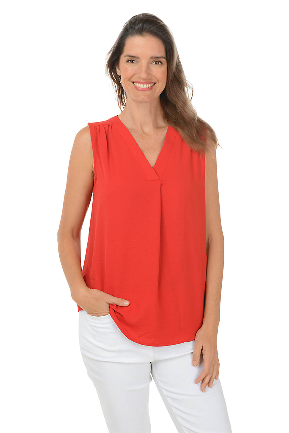 A front shot of a model wearing a sleeveless lipstick blouse with a V-neckline and a center front inverted pleat, paired with white pants.