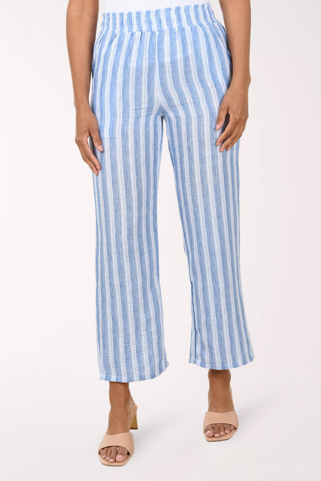 Blue and white striped pants worn by a person on a white background