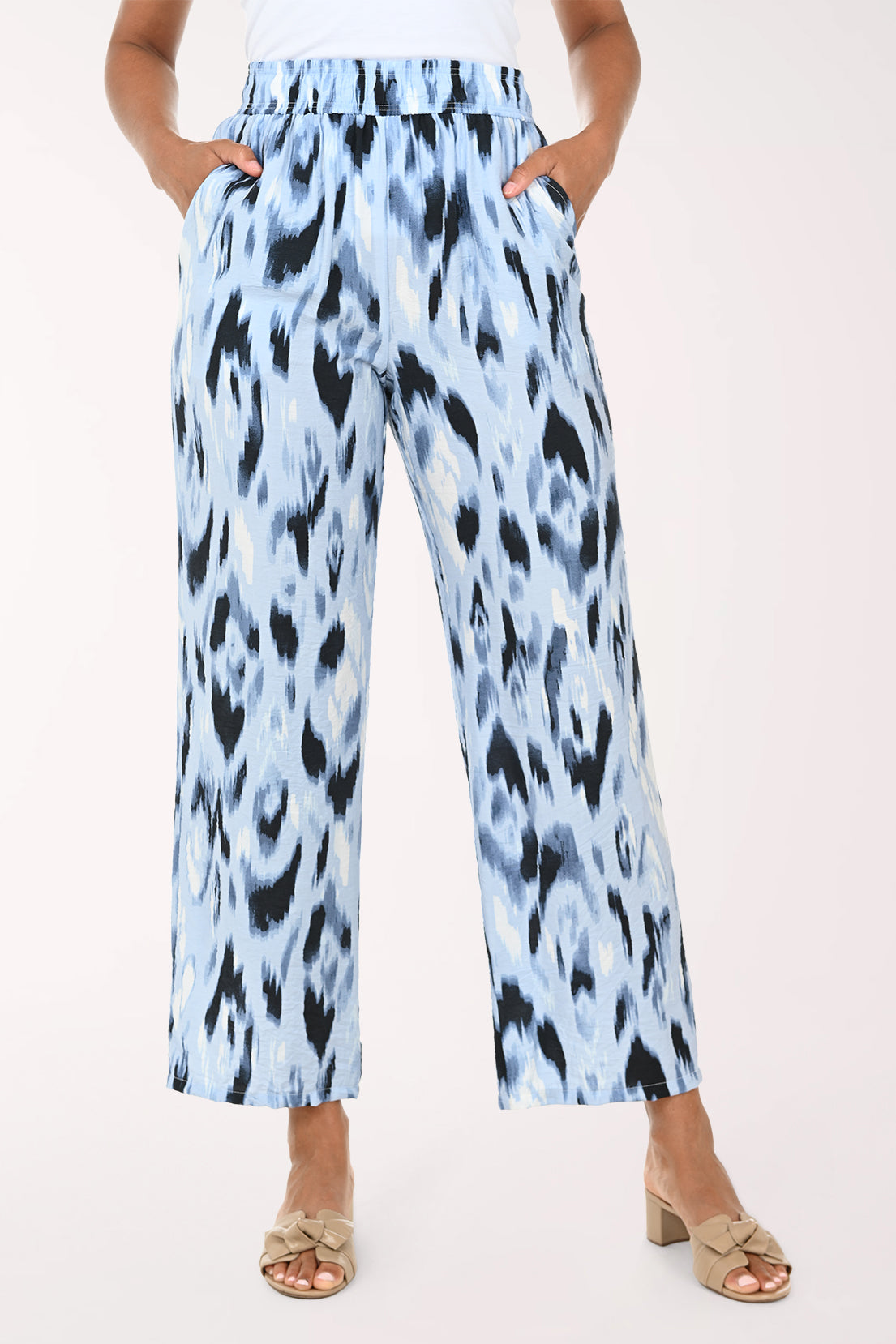 Light blue pants with black abstract pattern worn by a person on a white background