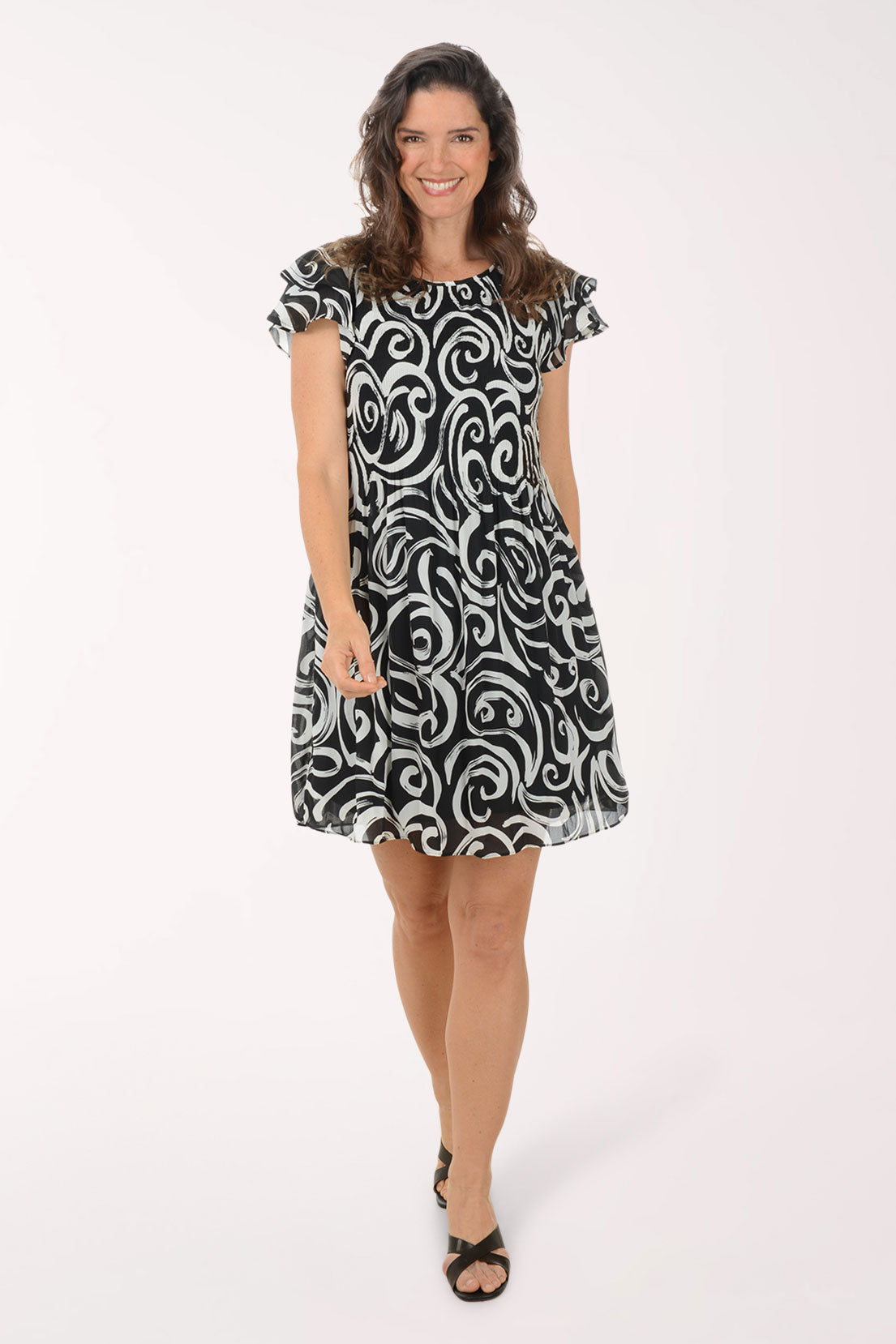 Woman wearing a black and white patterned dress on a white background