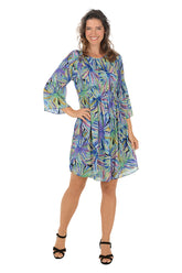 Woman wearing a colorful floral dress on a white background.