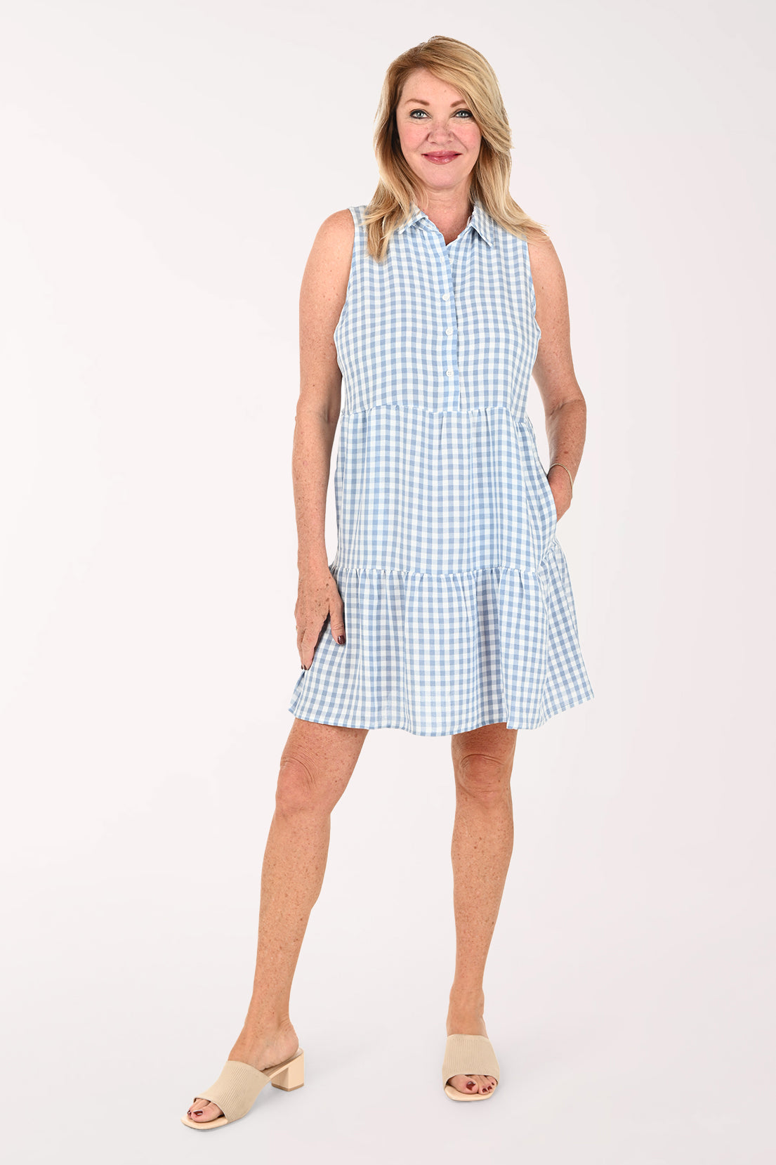 Woman wearing a sleeveless gingham blue dress
