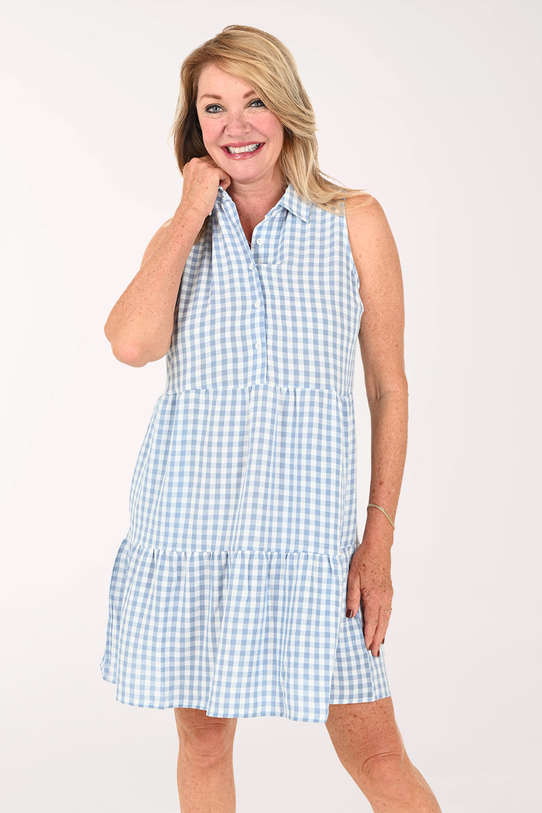 Woman wearing a sleeveless gingham blue dress