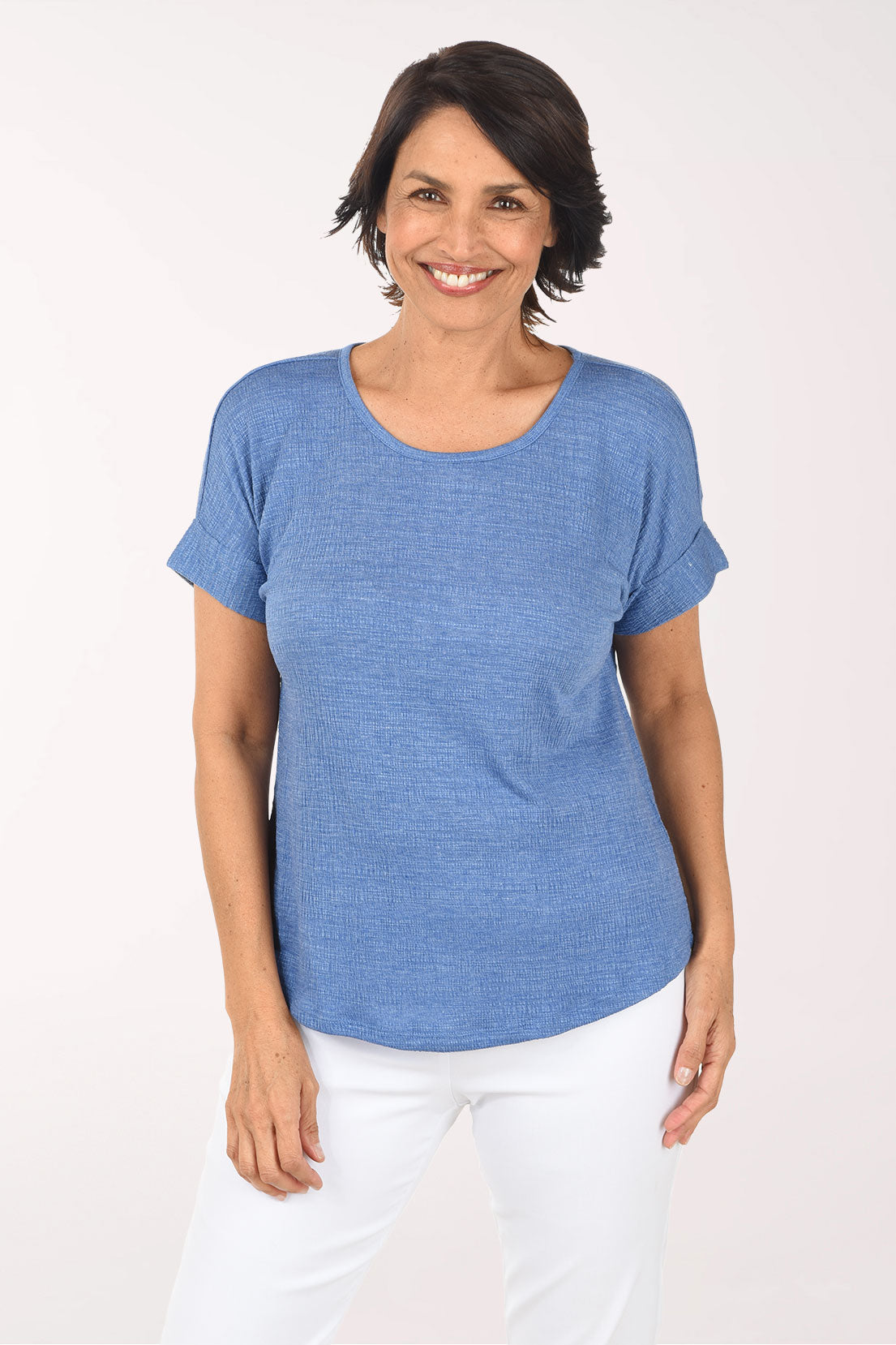Woman wearing a blue t-shirt and white pants on a white background