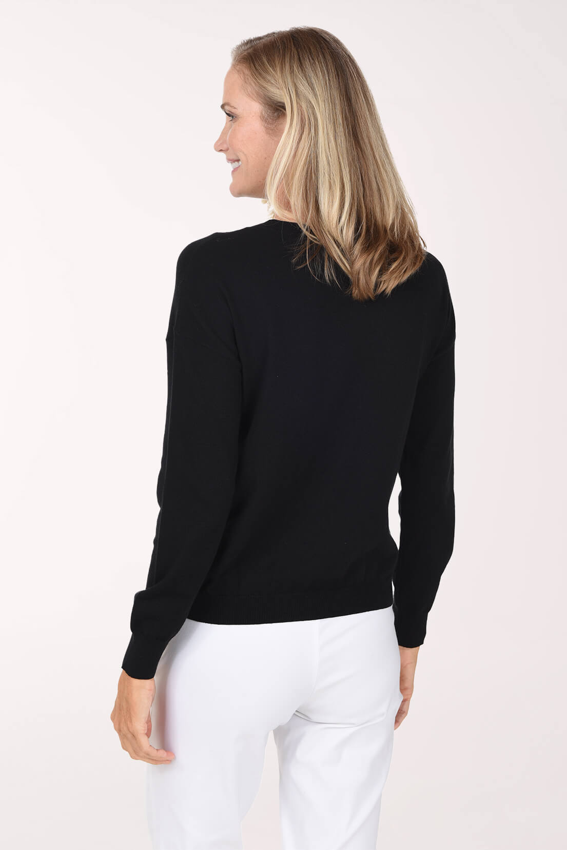 Model wearing a black sweater featuring a playful red and pink heart pattern.