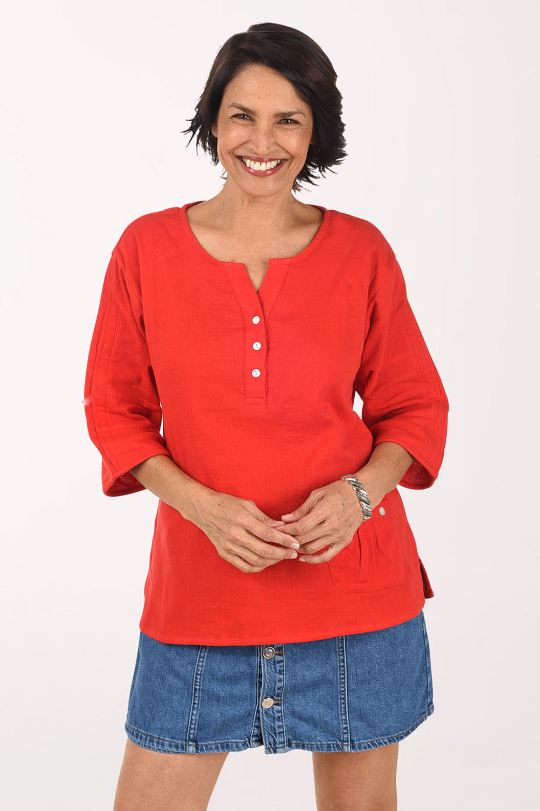 Woman wearing a red top and denim skirt on a white background