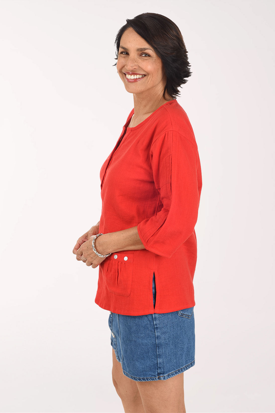 Woman wearing a red top and denim skirt on a white background