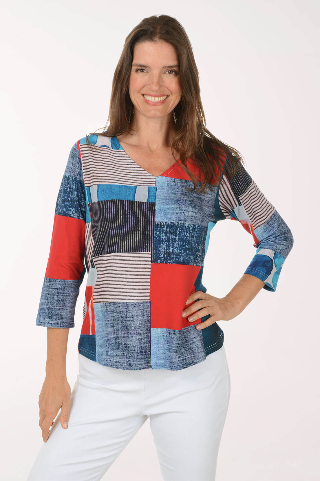 Woman wearing a colorful patchwork blouse against a white background