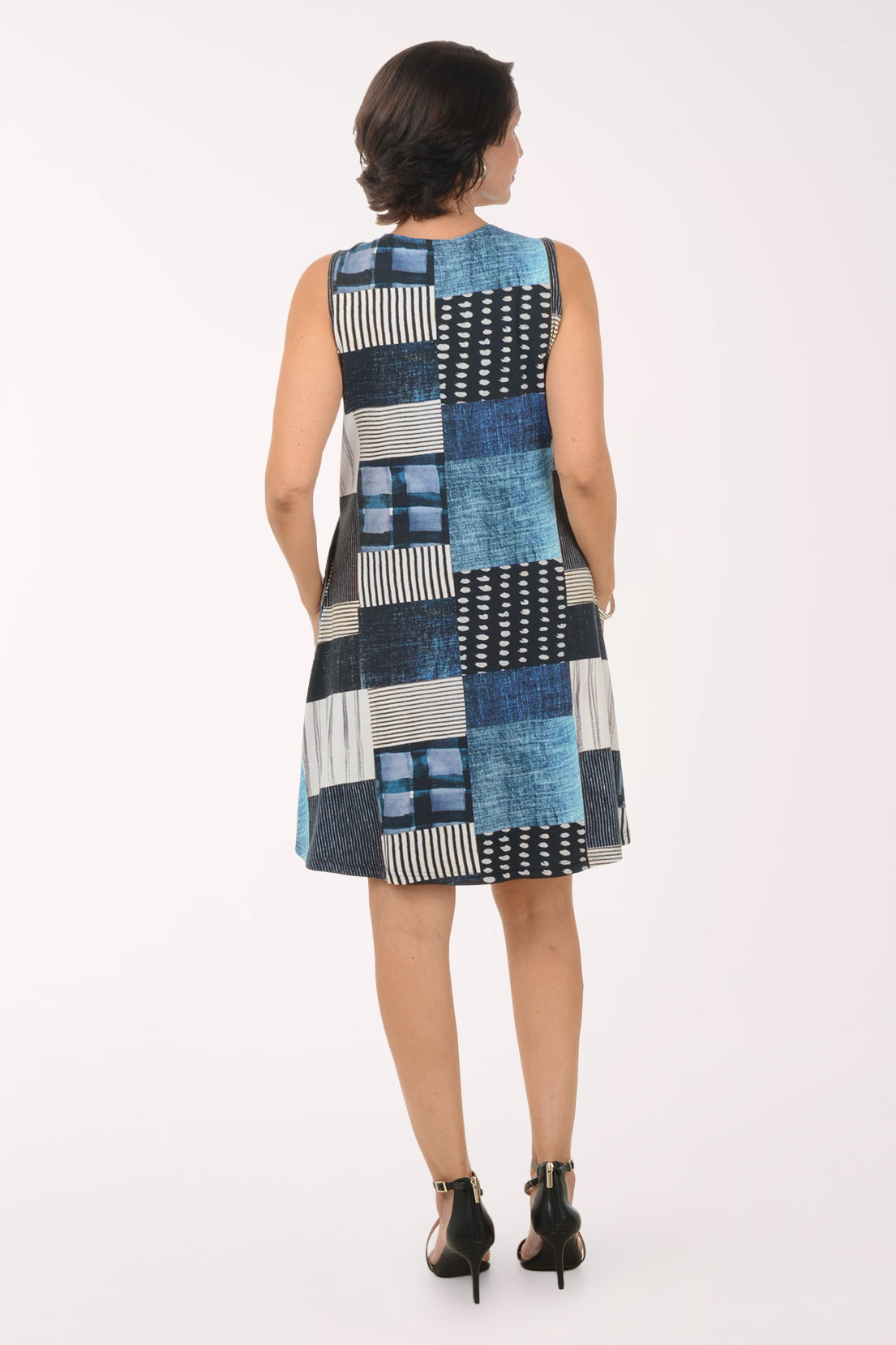 Woman wearing a patchwork dress with a white background