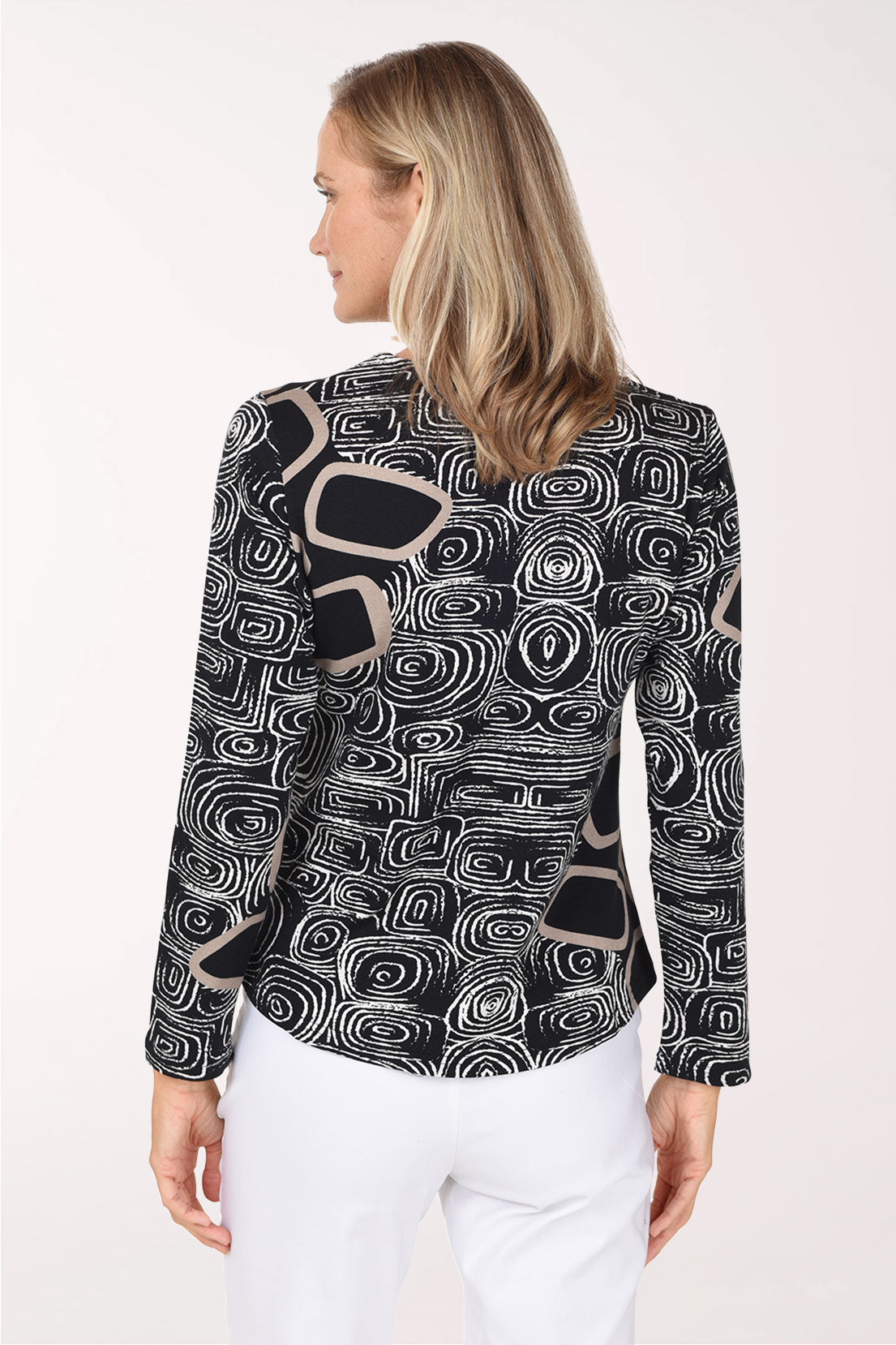 A woman wearing a black long sleeve shirt with a white swirl and square abstract print