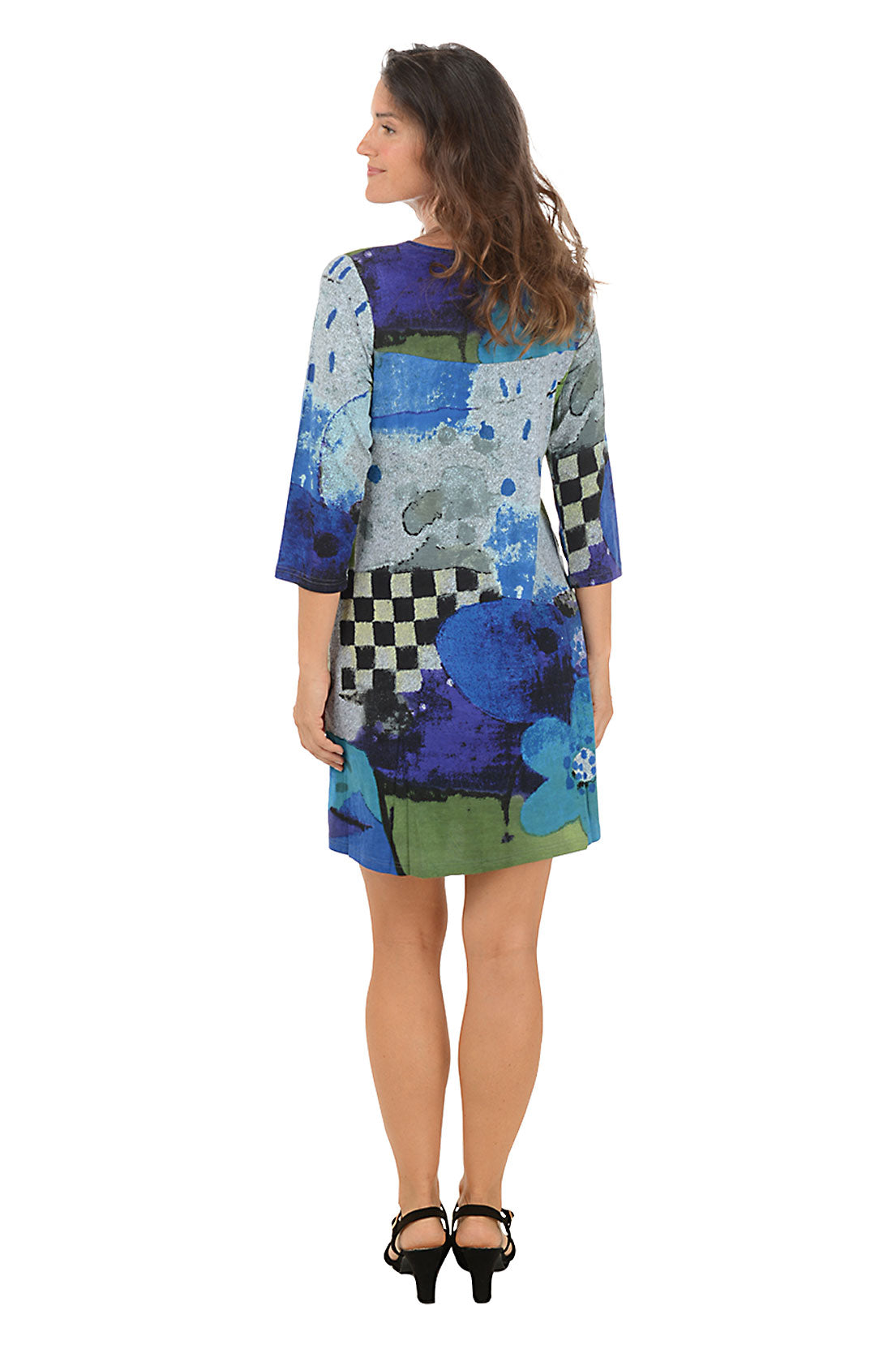 Woman wearing a colorful dress with abstract patterns on a white background. Back shot.