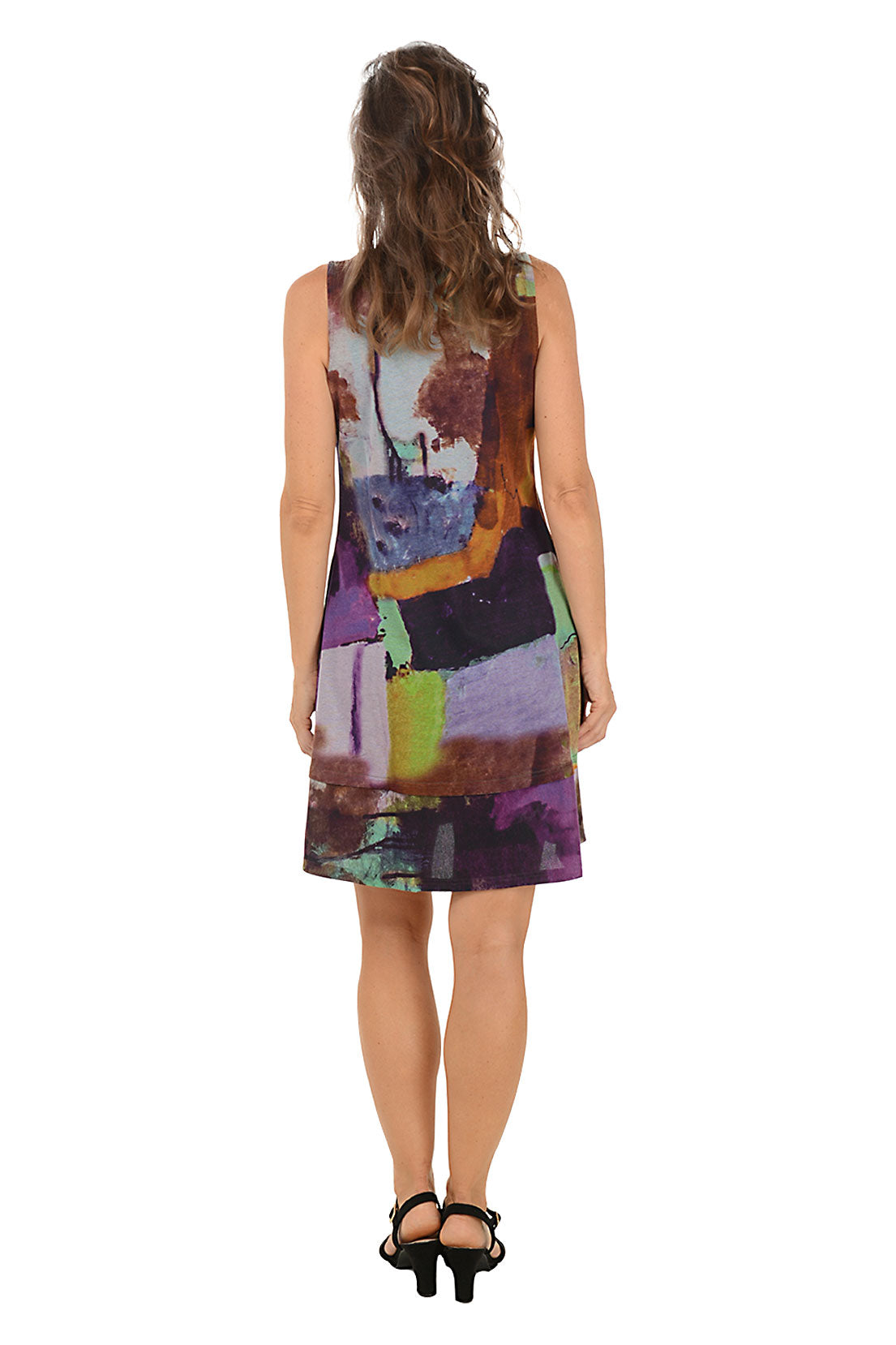 Woman wearing a sleeveless purple multi colorful dress on a white background. Back shot.