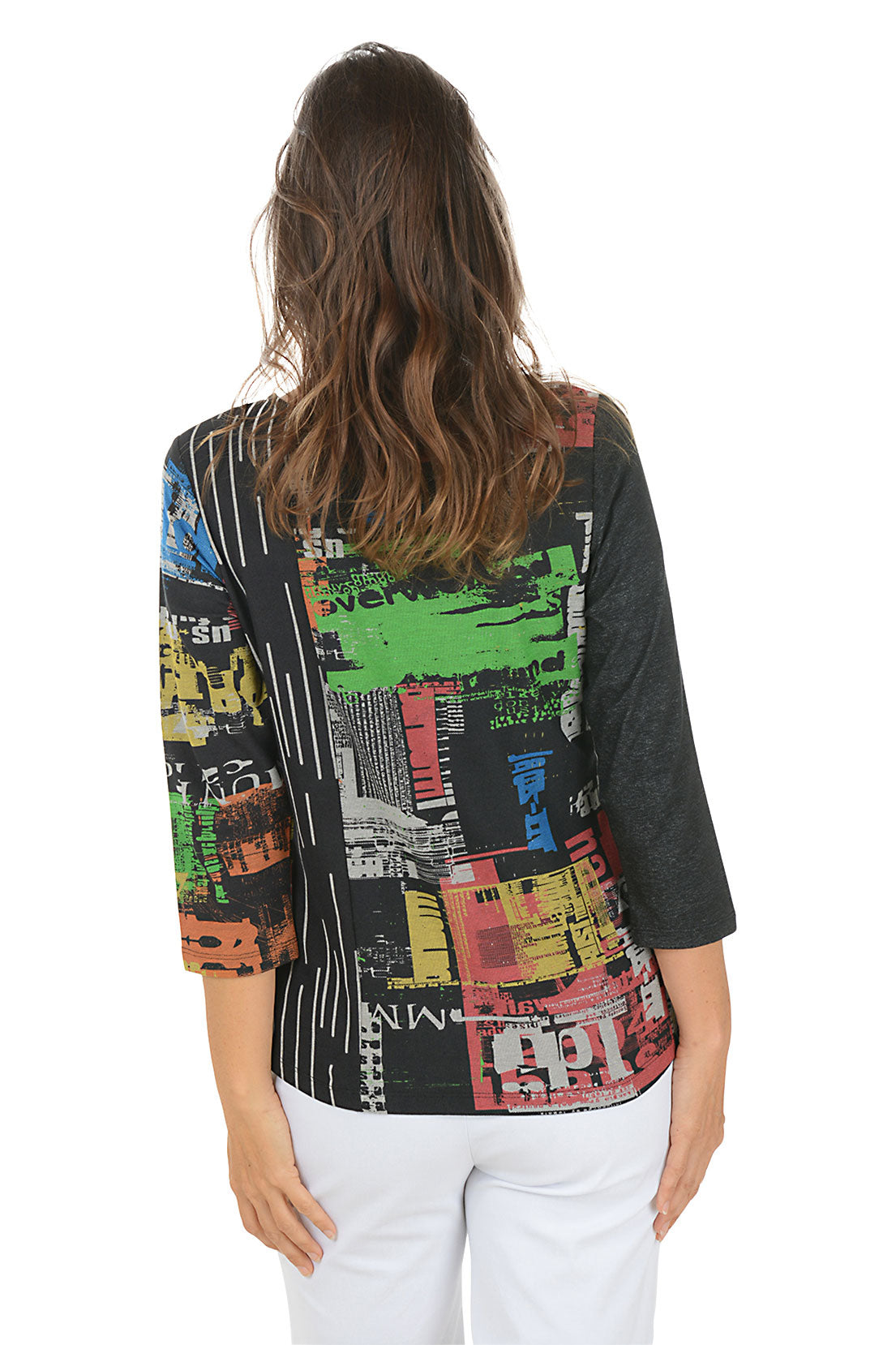 Woman wearing a 3/4 sleeve colorful typesetting patterned top with a white background. Back shot.