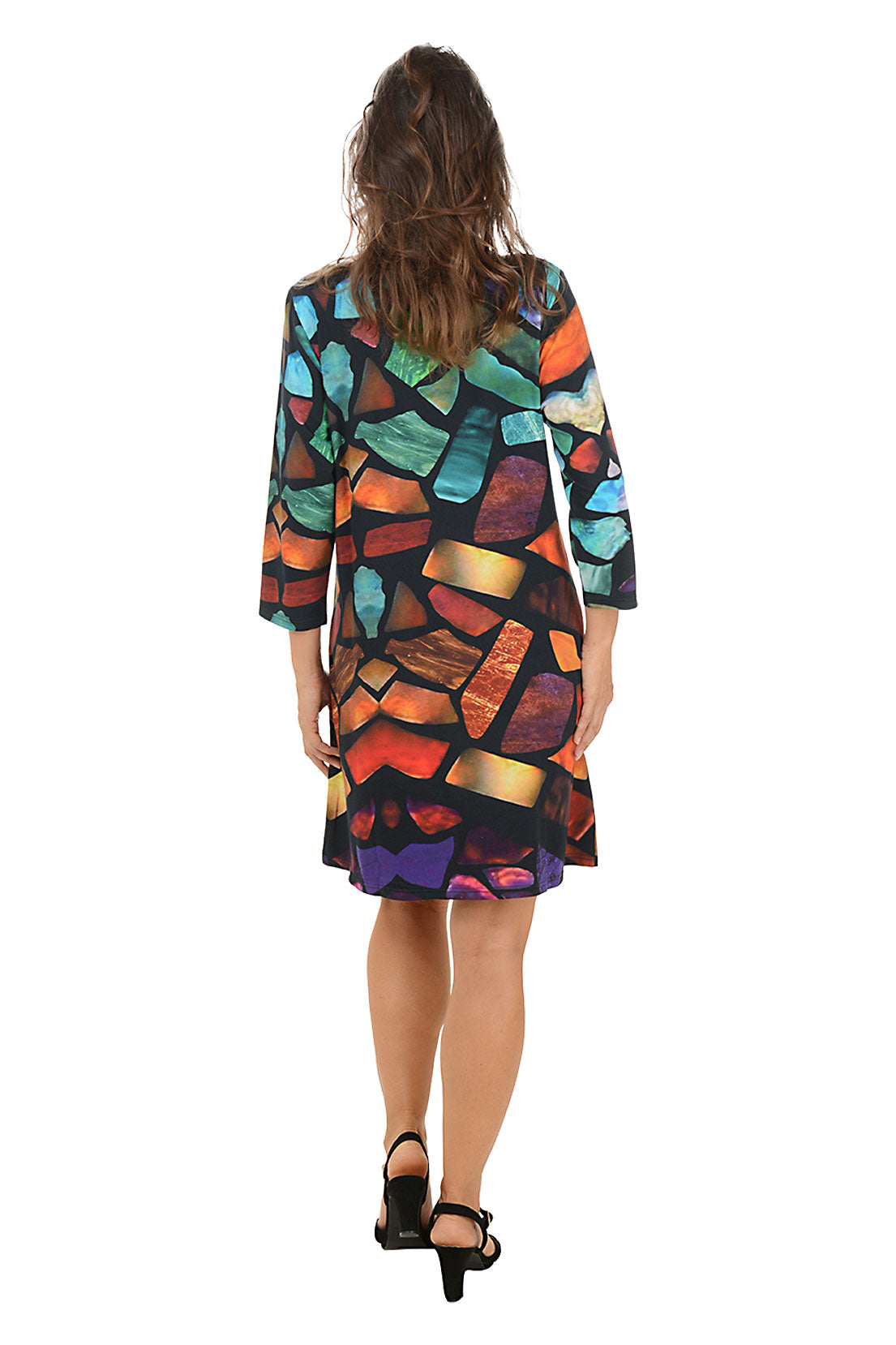 Woman wearing a 3/4 sleeve colorful abstract patterned dress with pockets on a white background. Back shot.