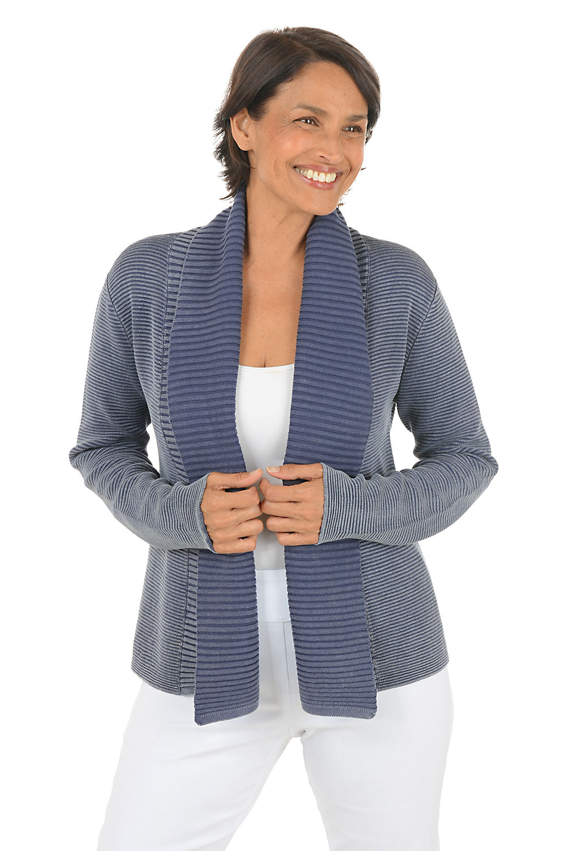 Woman wearing a blue knitted cardigan over a white top on a white background.