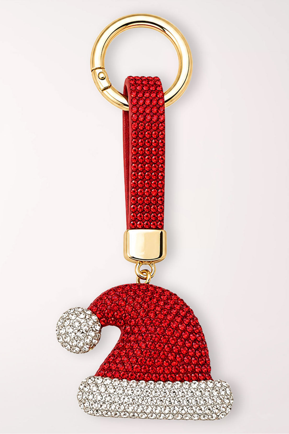 A red and white rhinestone Santa hat bag charm on a red rhinestone strap with a gold ring.