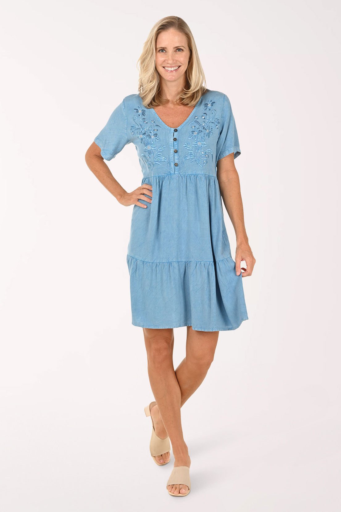 Woman wearing a blue dress with lace details on a white background