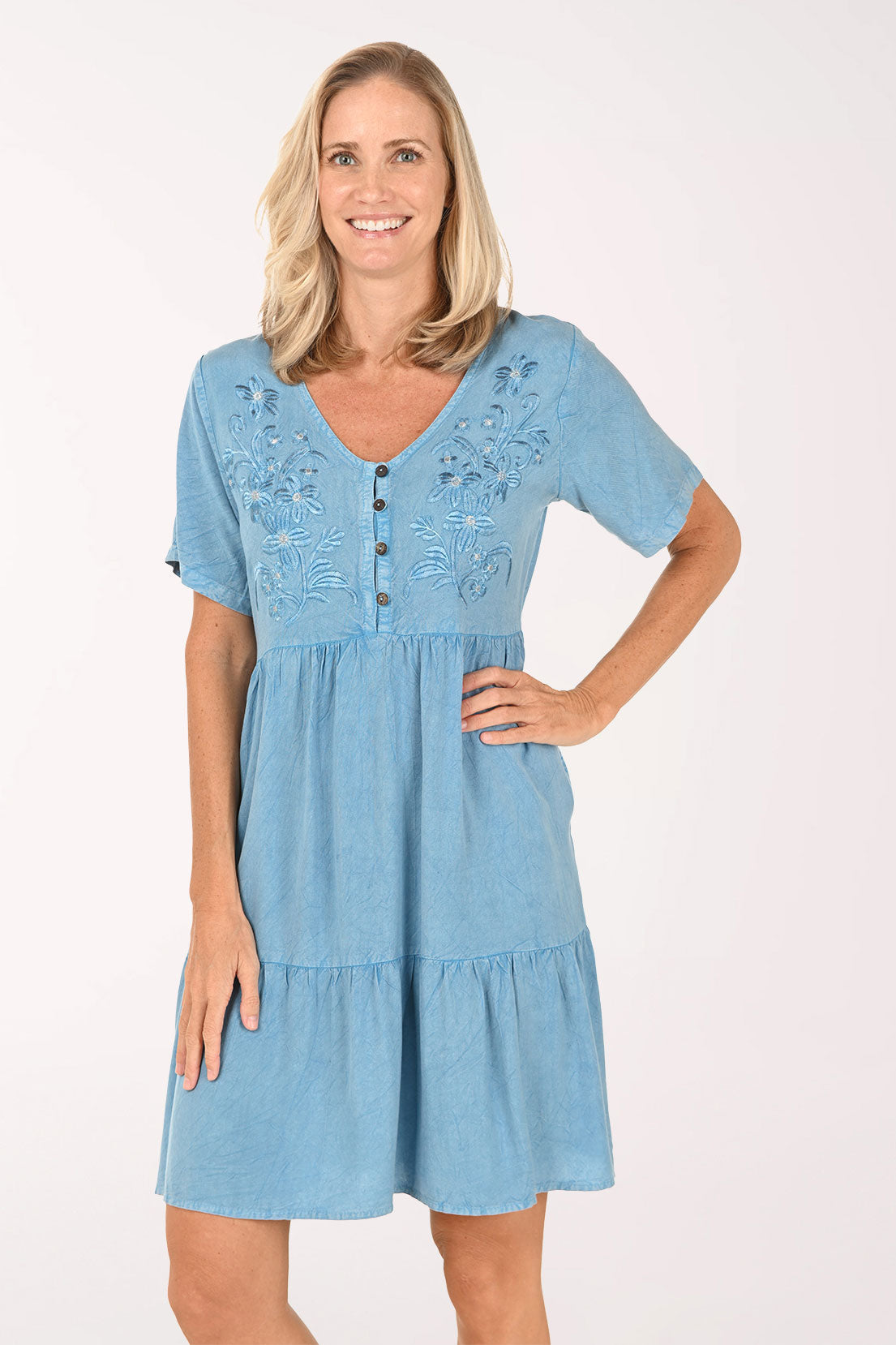 Woman wearing a blue dress with lace details on a white background