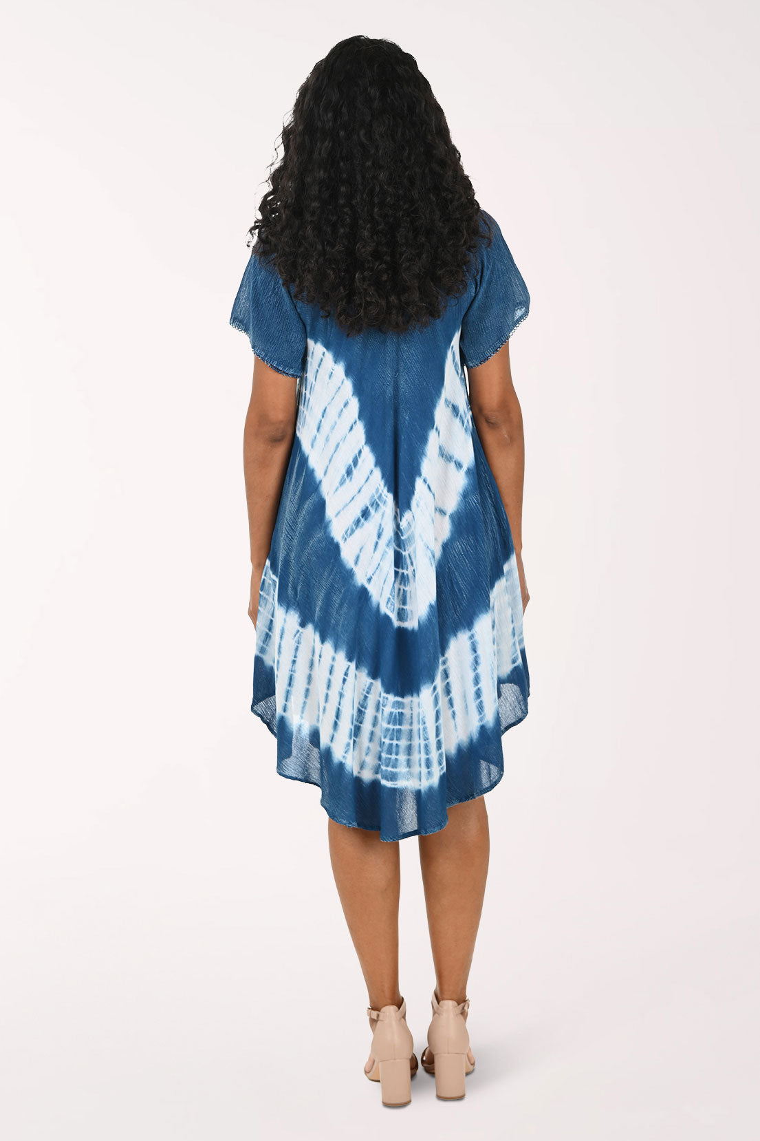 Woman wearing a blue and white tie-dye dress on a white background