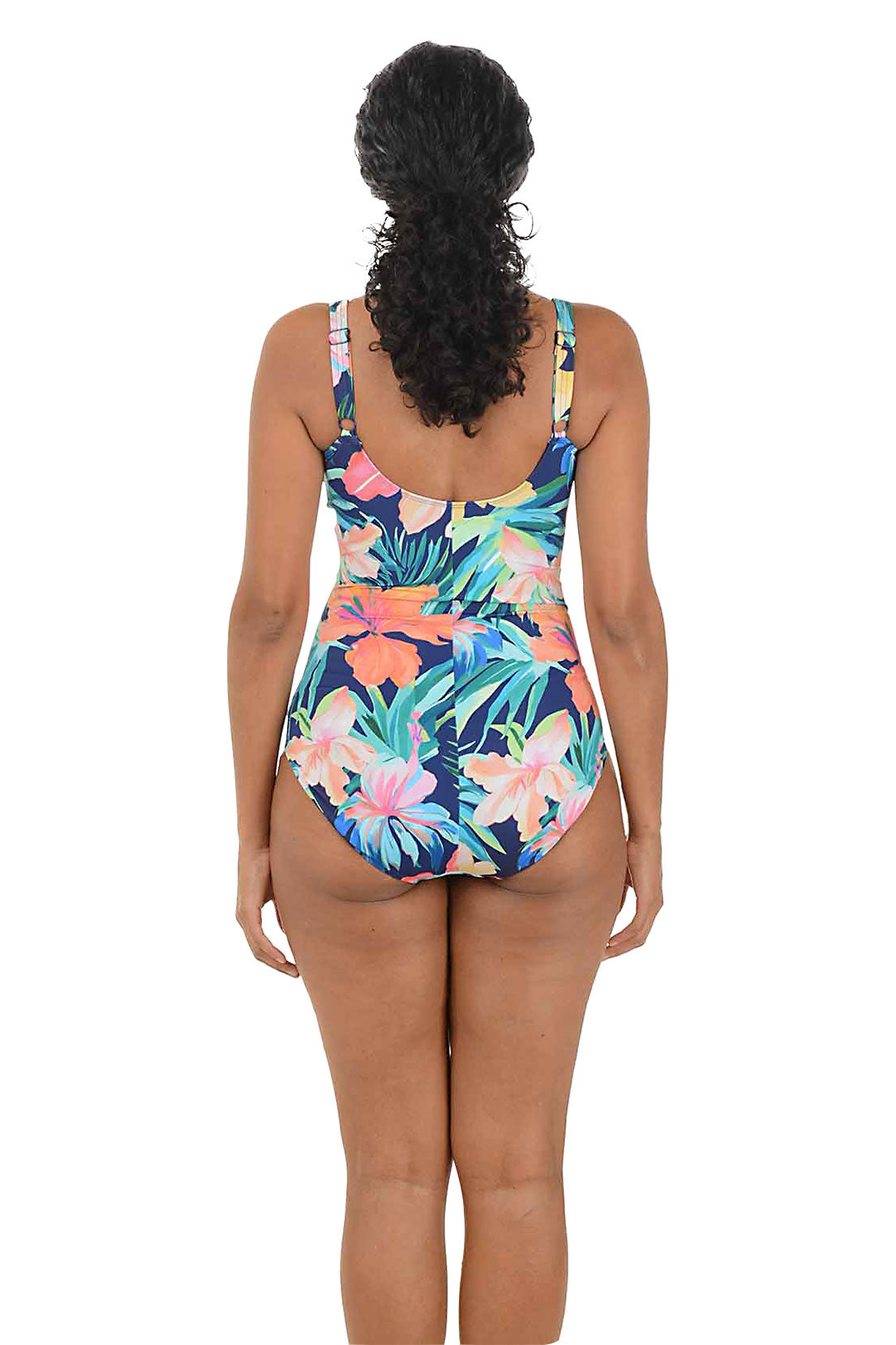 Woman wearing a colorful floral one-piece swimsuit on a white background. Back shot.