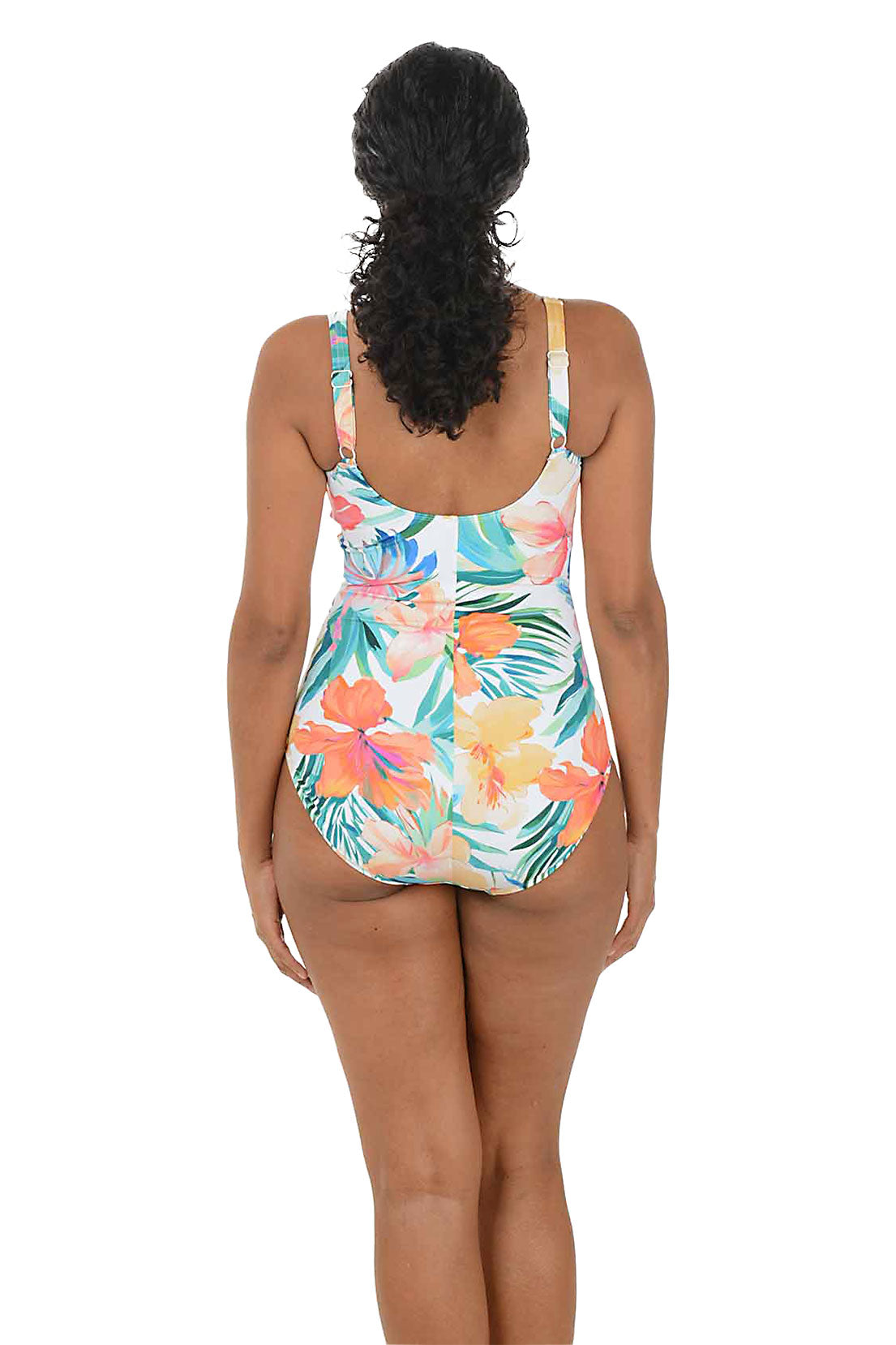 Woman wearing a colorful floral swimsuit on a white background. Back shot.