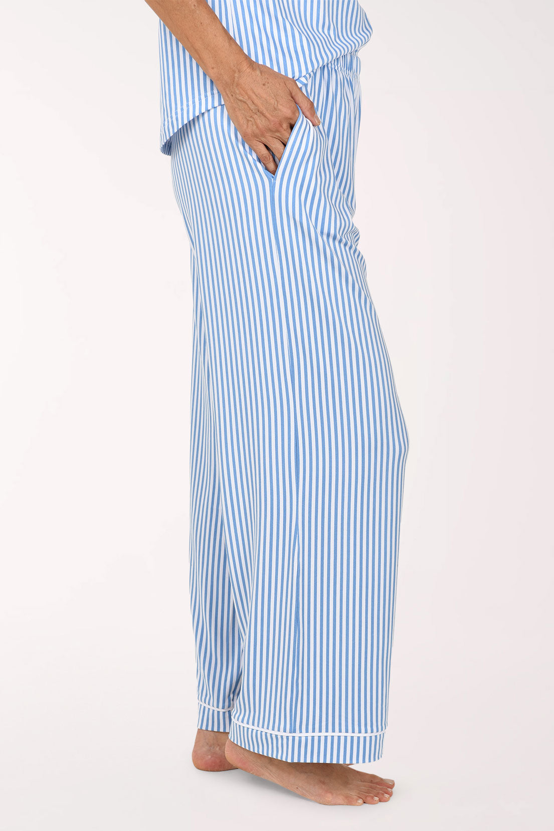 A person wearing light blue and white vertically striped pajama pants, shown from the waist down against a plain light background.