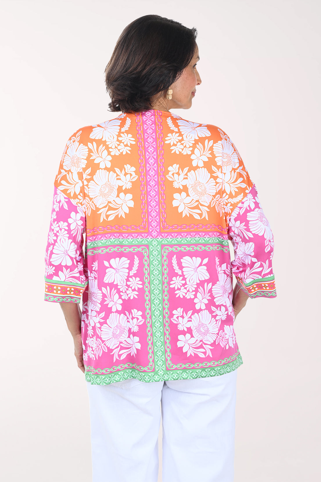 Woman wearing a colorful floral blouse with a white background