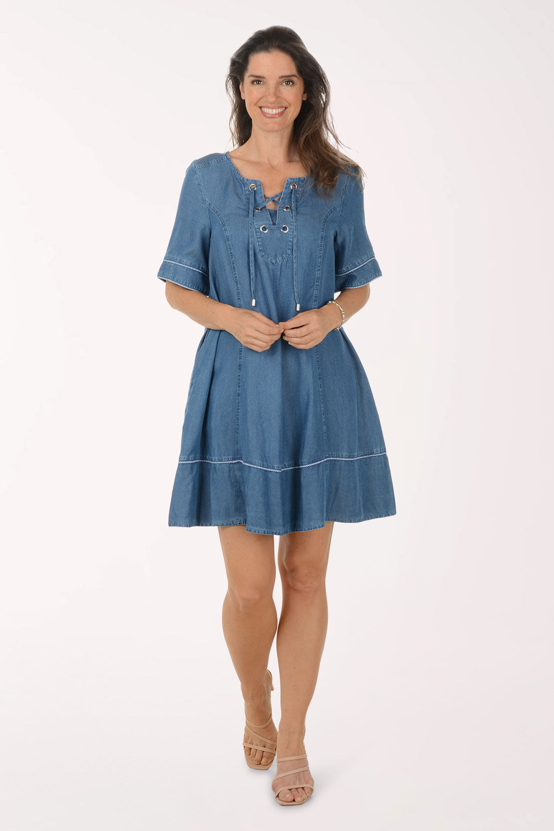 Woman wearing a blue denim dress on a white background