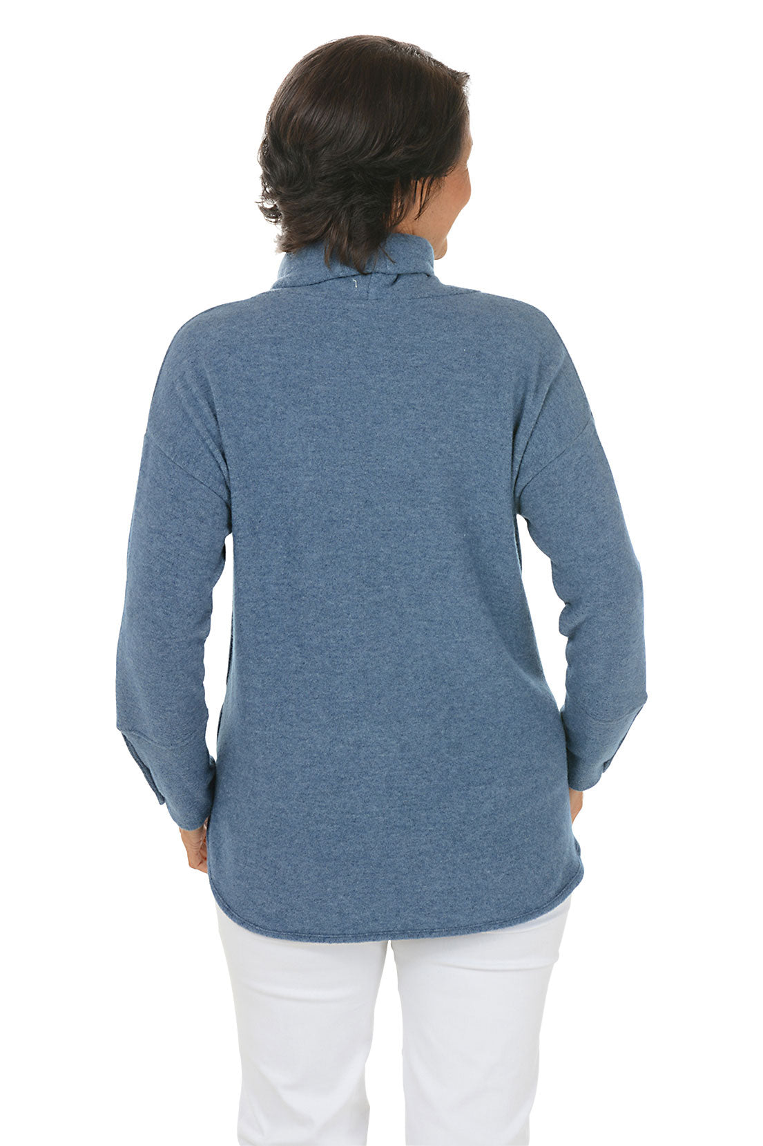 Woman wearing a blue cowl-neck sweater with white pants on a white background. Back shot.