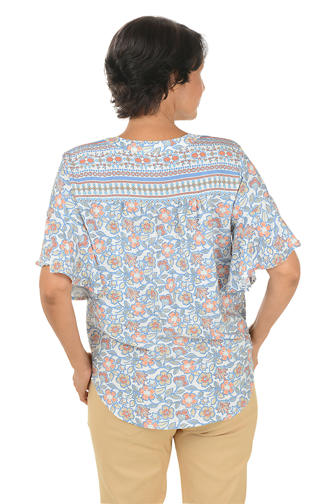 A back shot of a model wearing a blue sky floral blouse paired with stone pants.