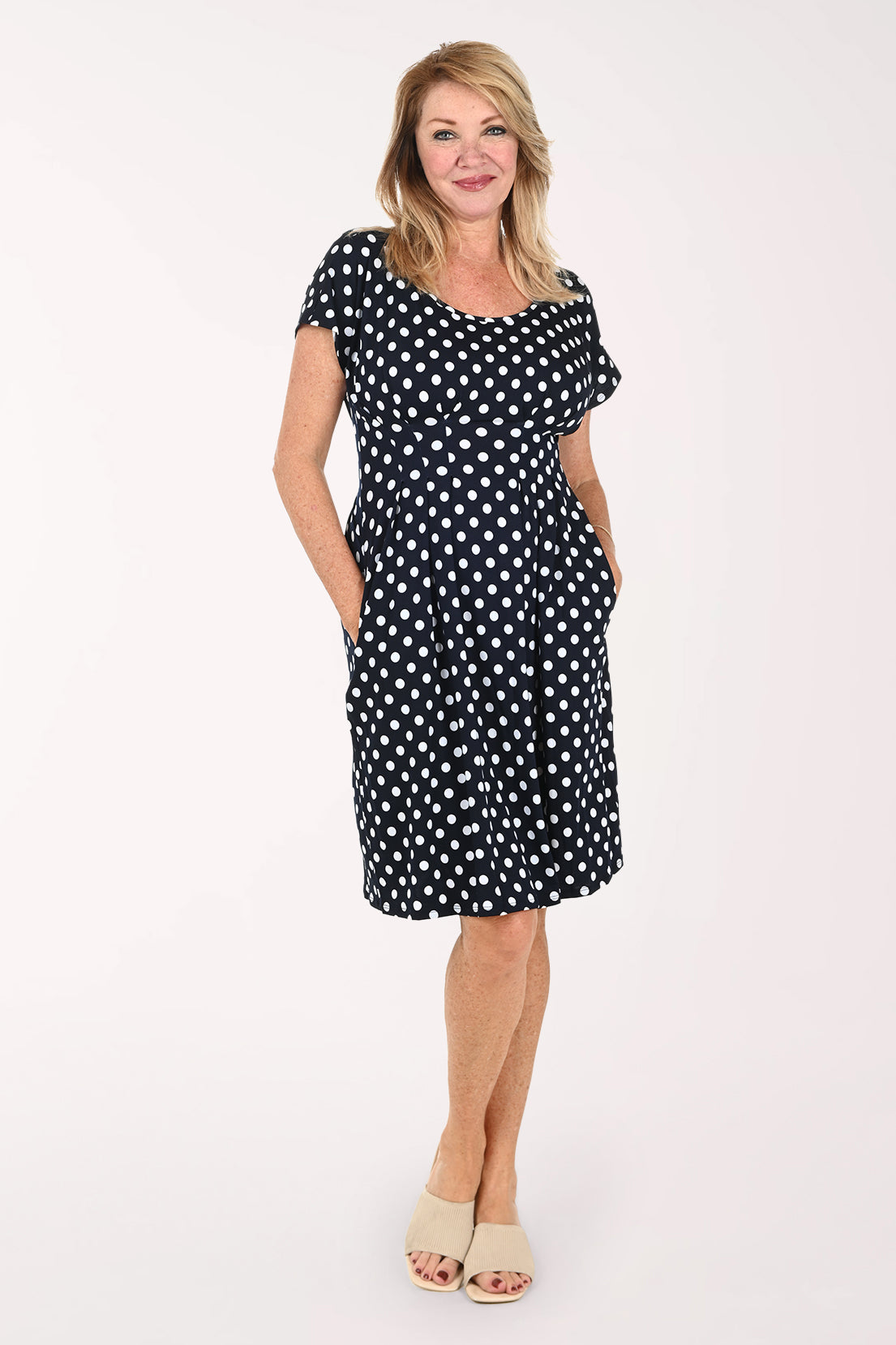 Woman wearing a short sleeve navy and white polka dot dress