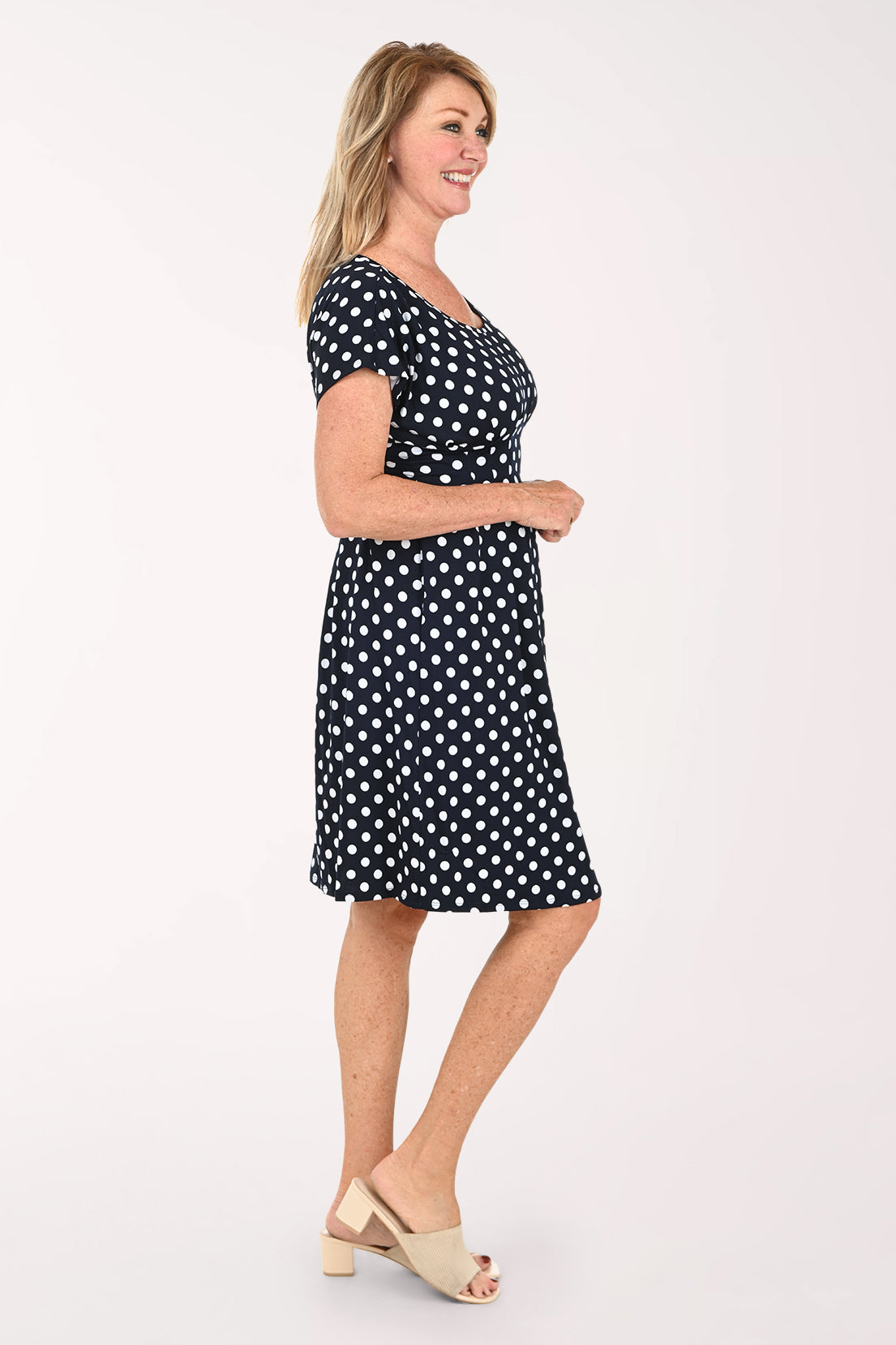 Woman wearing a short sleeve navy and white polka dot dress