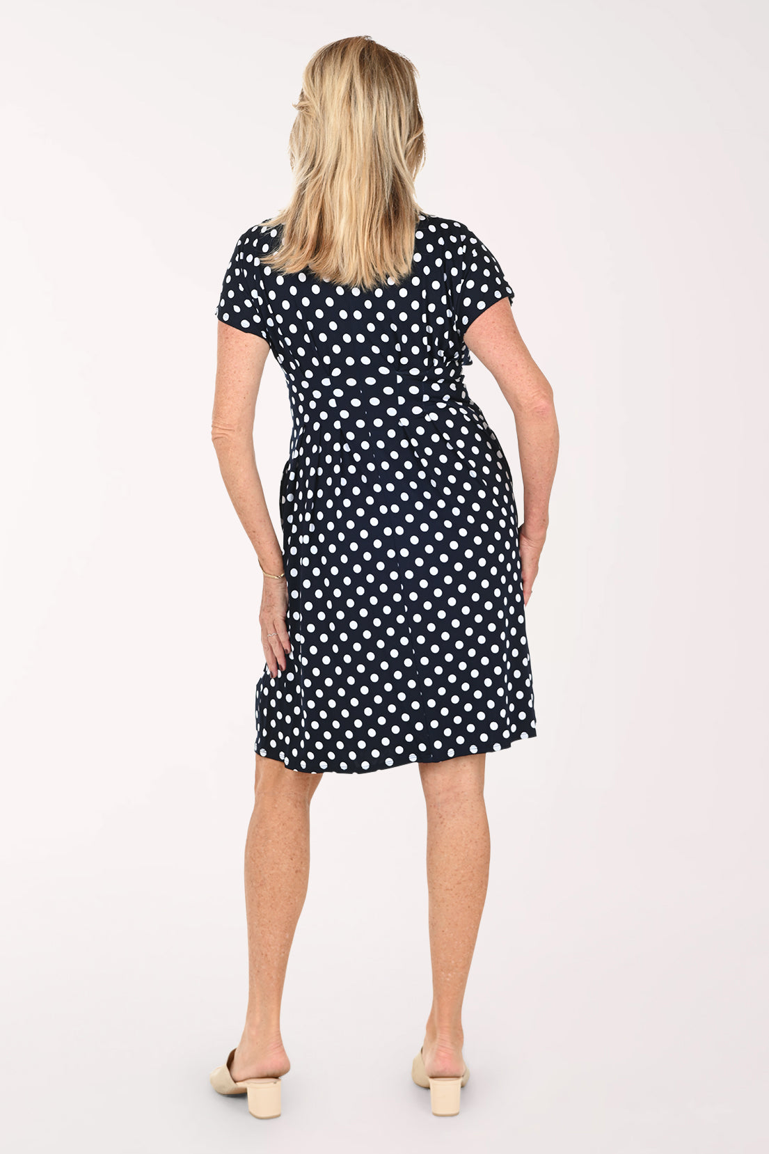 Woman wearing a short sleeve navy and white polka dot dress