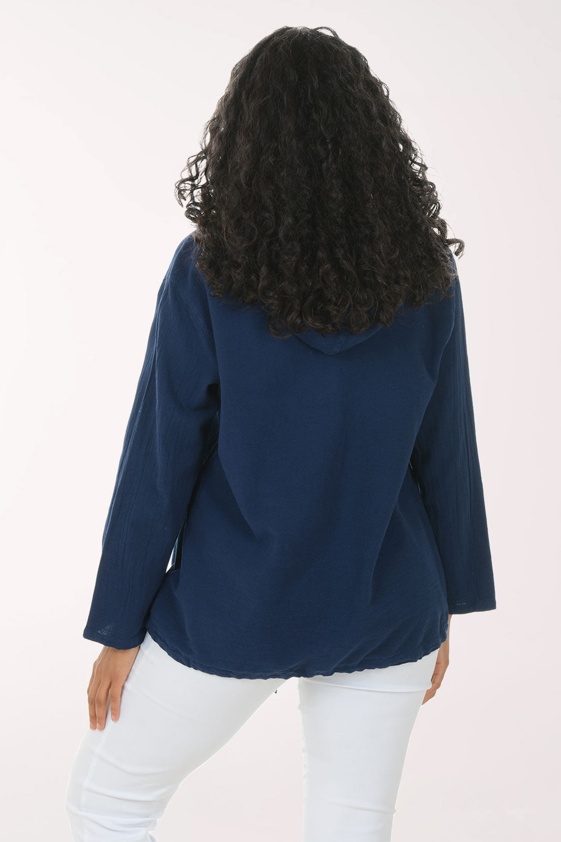 Woman wearing a navy blue cardigan with gold buttons on a white background