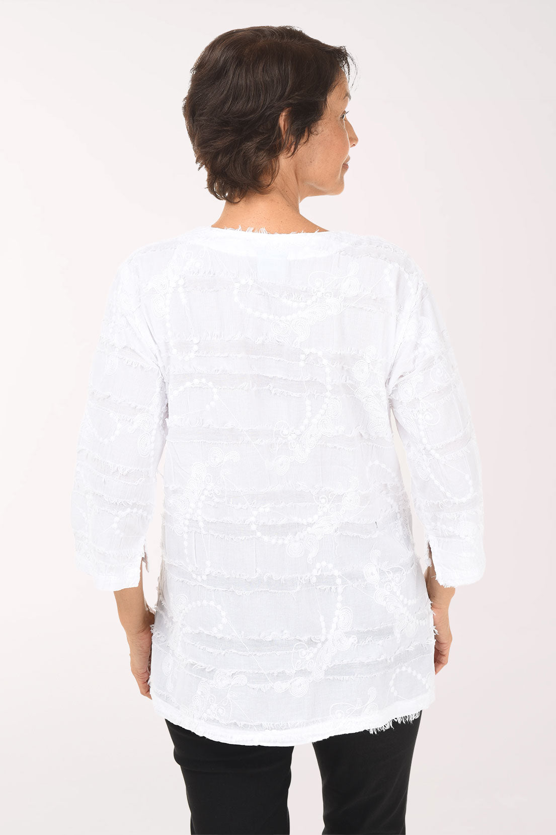 Woman wearing a white blouse with black pants on a white background