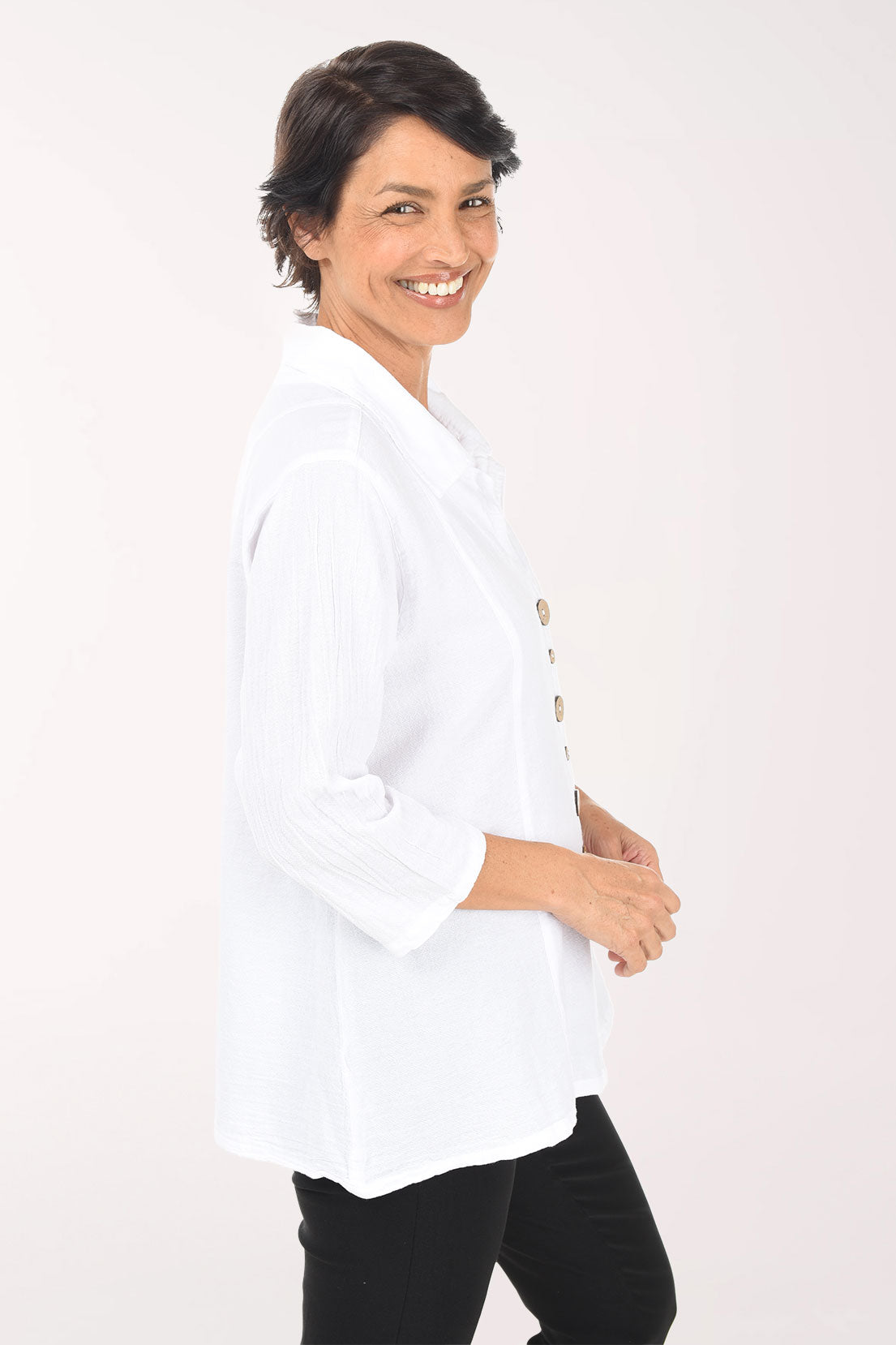 Woman wearing a white blouse with buttons on a white background