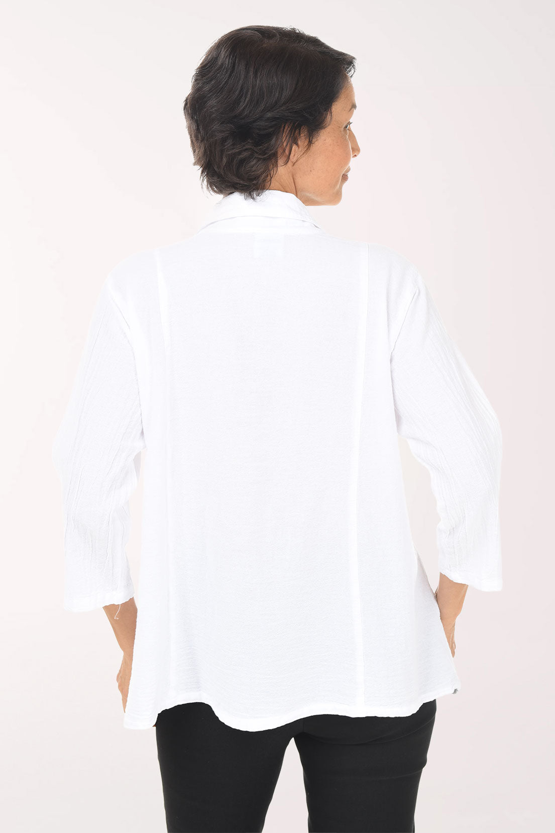 Woman wearing a white blouse with buttons on a white background
